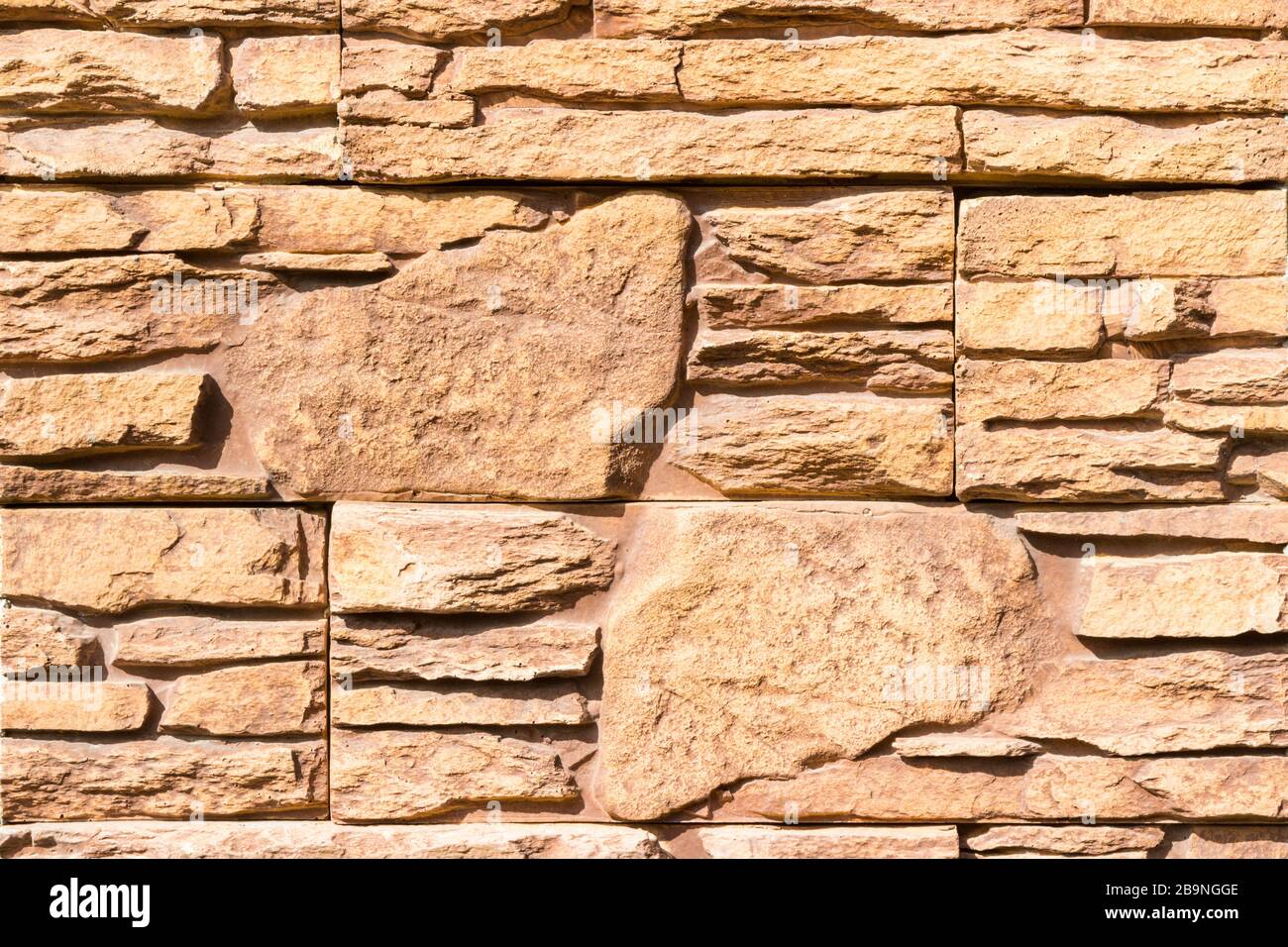 Paneles de piedra falsa marrón pared patrón de fondo Fotografía de