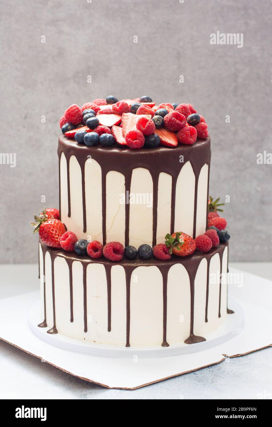 Un Pastel De Boda Blanco De Tres Niveles Decorado Con Bayas Frescas Y Brillantes Y Chocolate Derretido Fotografía De Stock Alamy<script async src=