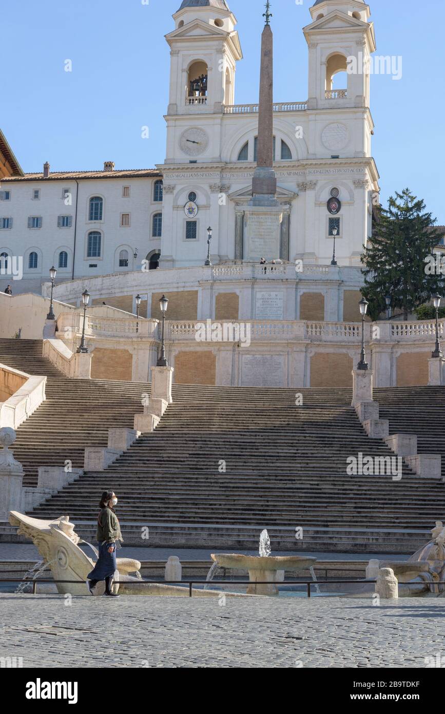 ROMA, ITALIA - 10 de marzo de 2020: Una mujer turística que lleva una máscara de cara camina frente a los pasos españoles en Roma, Italia. Hoy, el gobierno italiano Foto de stock