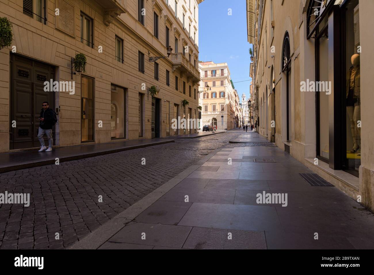 ROMA, ITALIA - 12 de marzo de 2020: Un hombre camina por la calle que conduce a los pasos españoles, vacío hoy después de los meas de confinamiento de la pandemia del coronavirus Foto de stock