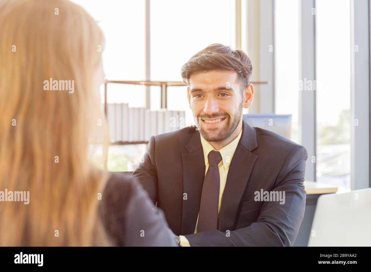 Retrato de un sonriente empresario europeo apretón de manos con su pareja empresarial femenina, dos personas exitosas se felicitan unos a otros agitando la mano Foto de stock