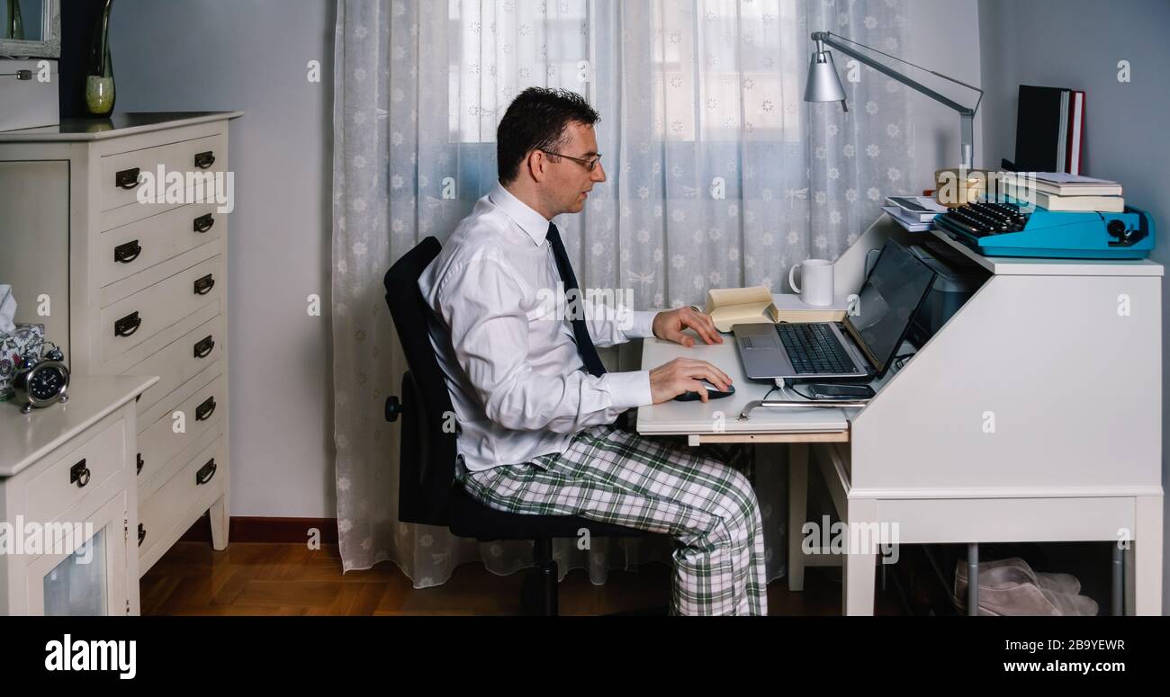 Hombre teletrabajo usando camisa, corbata y pantalones de pijama Fotografía  de stock - Alamy