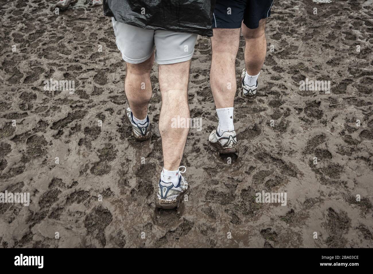 dos hombres caminando en campo fangoso en sportswear Foto de stock
