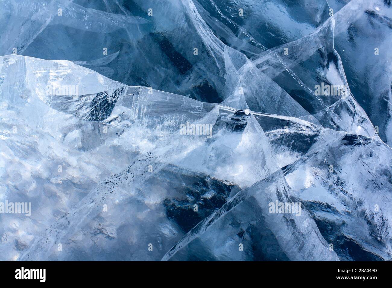 El hielo del lago estaba muy agrietado. Hielo azul claro con grietas blancas. Horizontal. Foto de stock
