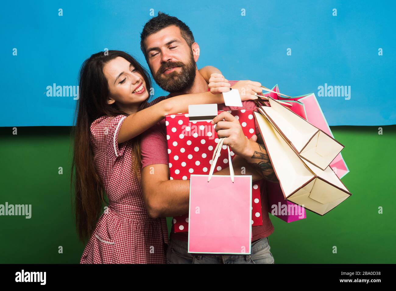 Macho tiene una bolsa de compras. Concepto de compras y moda. Un chico con  barba y una señora bonita con caras felices hacen compras. Pareja en  abrazos de amor, tiene grandes cajas