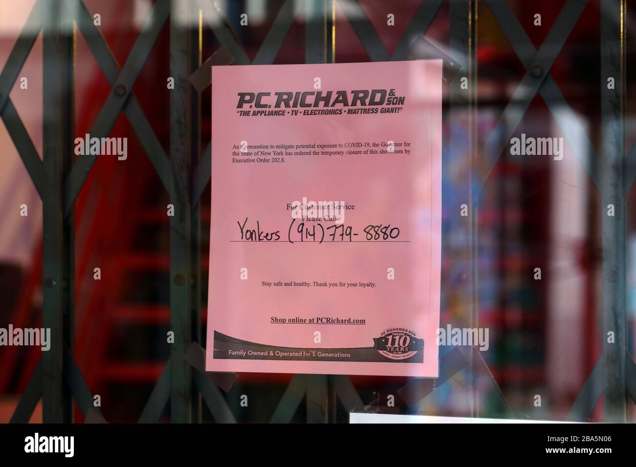 Nueva York, NY, 24 de marzo de 2020. Un cartel en una puerta a una tienda de electrodomésticos que notifica a los clientes como medida de precaución para mitigar la posible propagación de la pandemia de COVID-19 del coronavirus, el Gobernador del Estado de Nueva York ha emitido la Orden Ejecutiva 202.8, por la que se ordena el cierre de empresas no esenciales para combatir la propagación de una pandemia. Crédito: Robert K. Chin. Foto de stock