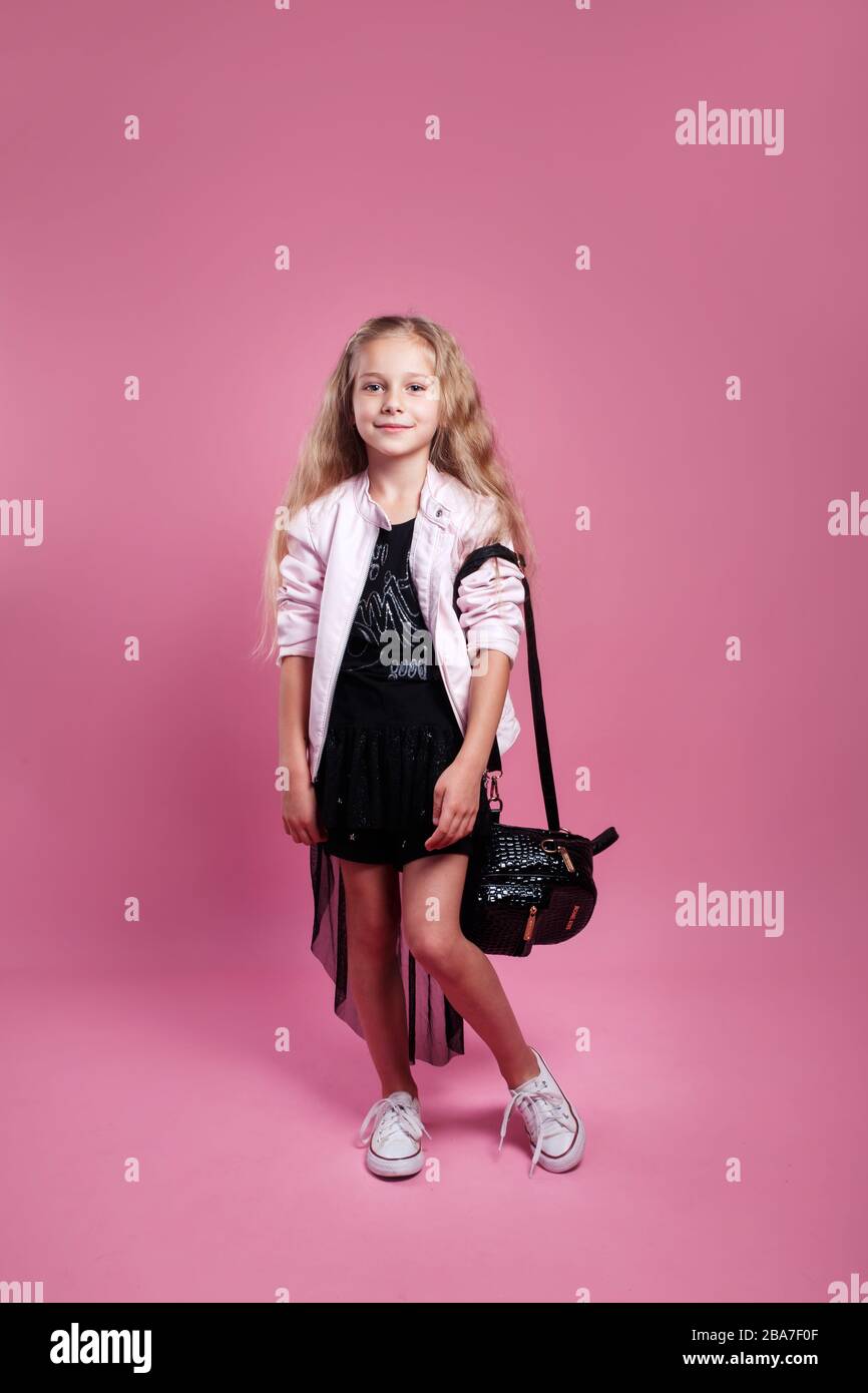 Tormenta reforma Doctor en Filosofía niña de moda con vestido negro y chaqueta de cuero rosa posando sobre fondo  rosa estudio Fotografía de stock - Alamy