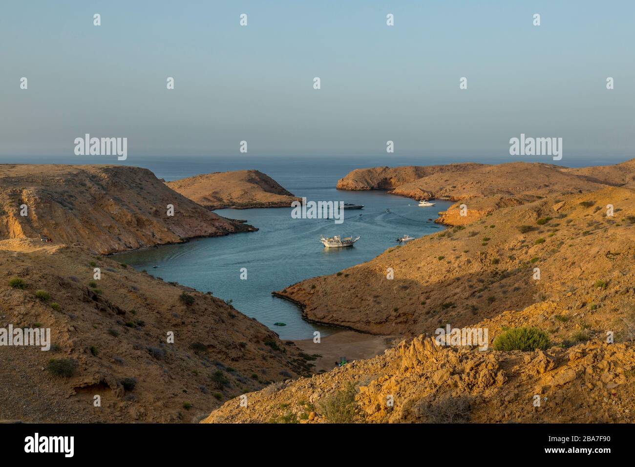 Una bahía en Bander al Khayran, o Bander al Khairan, justo al este de Muscat en Omán. Los barcos de placer se pueden ver en la bahía. Foto de stock
