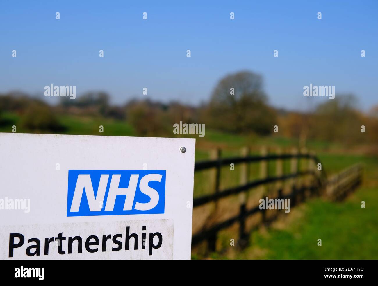 NHS palabra de asociación vista en una señal de carretera con fondo de campo borrosa. Foto de stock