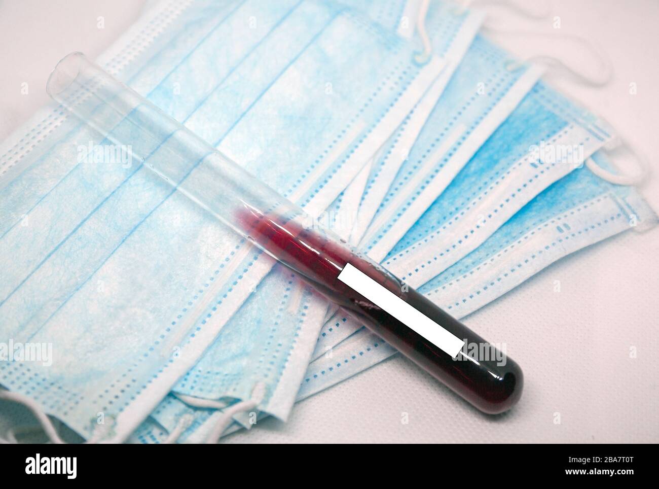 Mascarilla de protección quirúrgica con tubo de análisis de sangre. Foto de stock