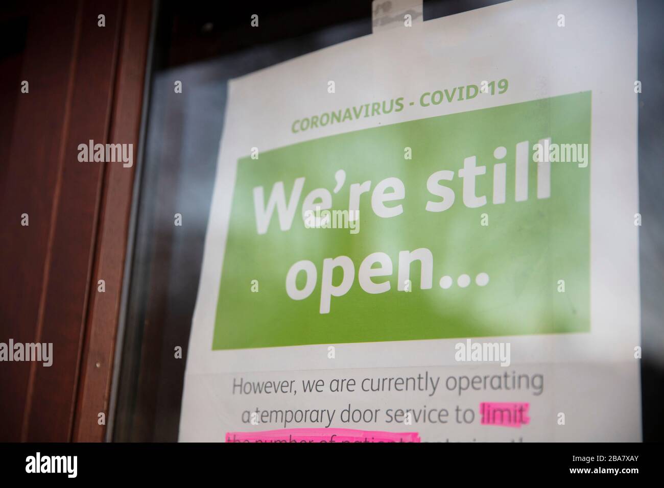 Una señal fuera de una tienda que promueve el distanciamiento social durante el brote de coronavirus Foto de stock