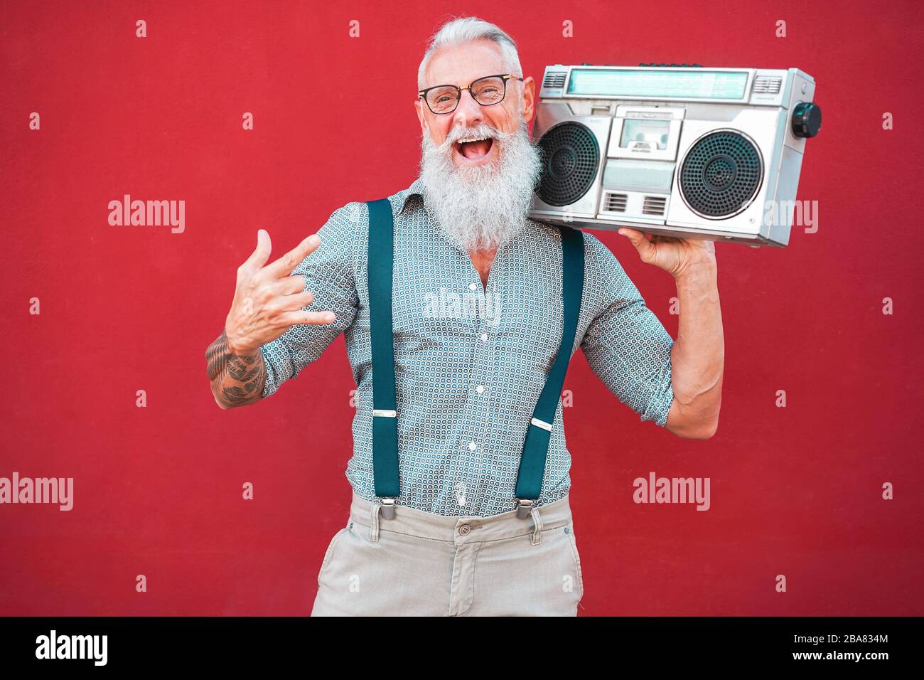 Anciano loco con estéreo boombox de los 80 tocando música rock con fondo  rojo - moderno chico maduro que se divierte bailando con la radio vintage -  alegre el Fotografía de stock - Alamy
