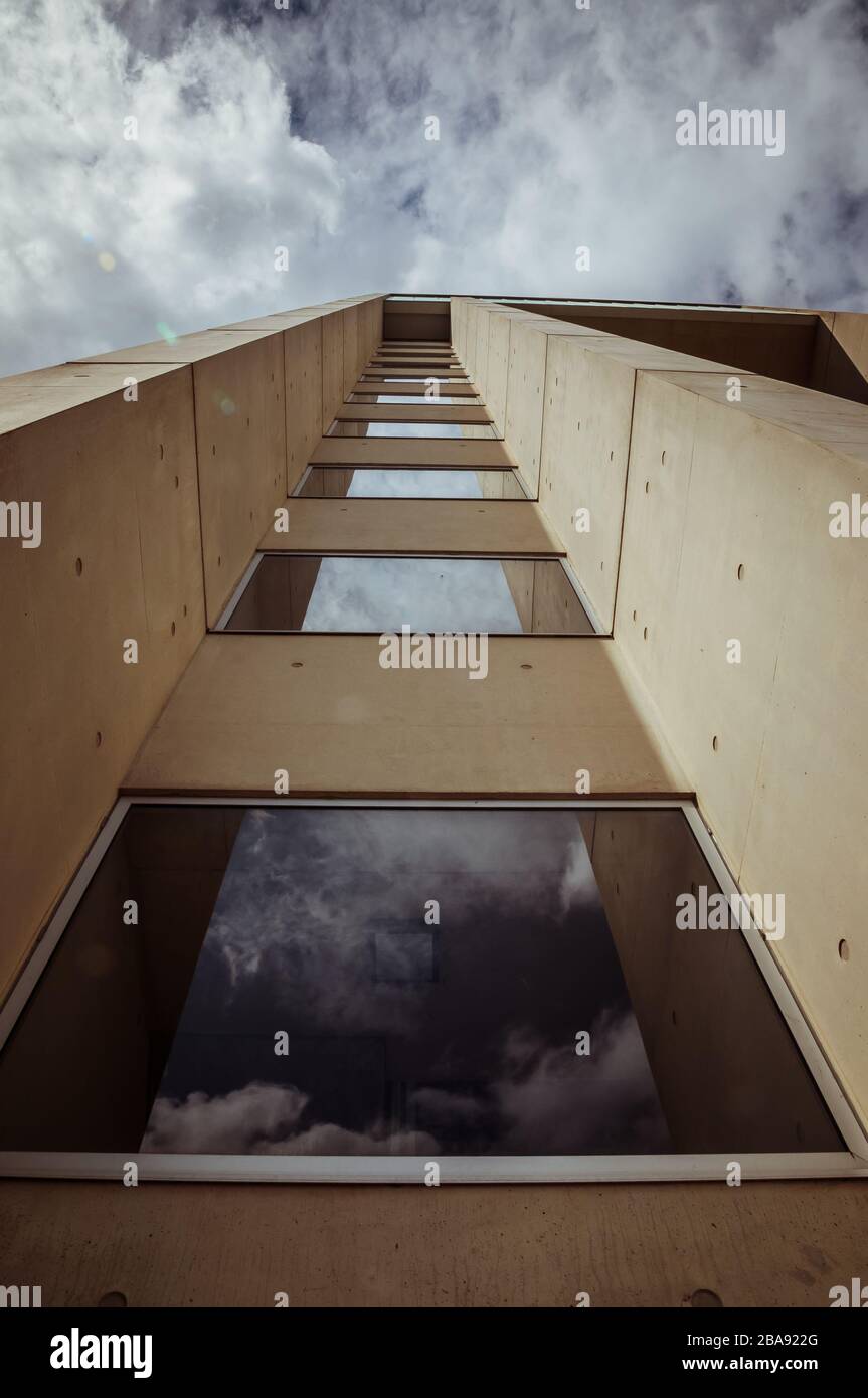 Hermosos detalles arquitectónicos de un edificio moderno de hormigón y fibra de vidrio, con vistas a un cielo azul nublado Foto de stock