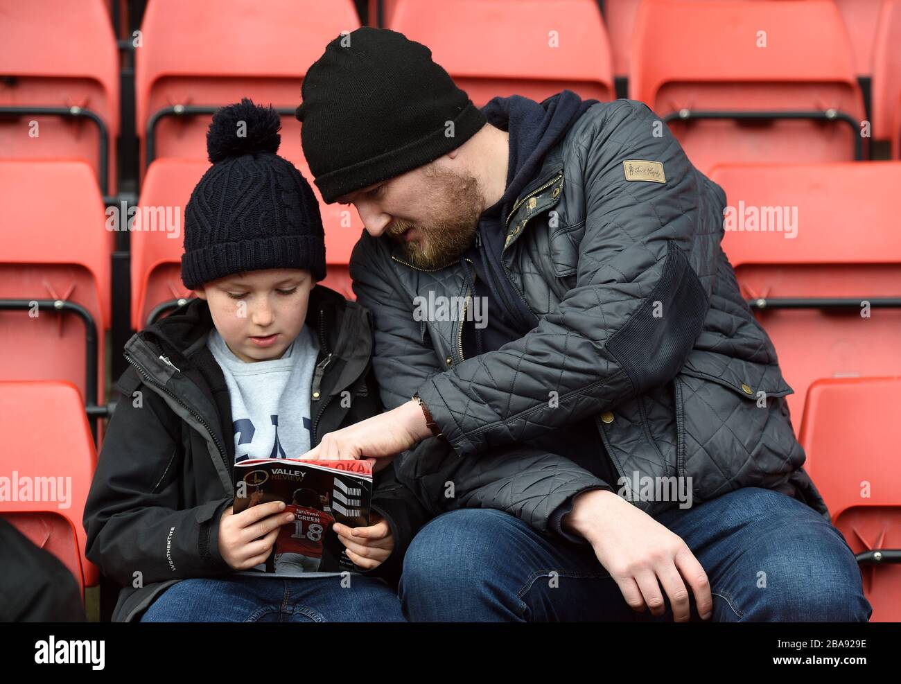 Los fans de Charlton Athletic leen el programa del día del partido Foto de stock