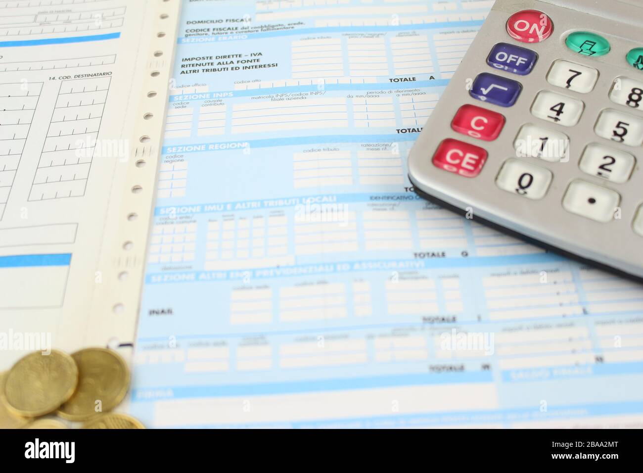 Formulario F23 / F24 para pagar impuestos en Italia al banco. Detalle con calculadora y monedas en euros. Foto de stock