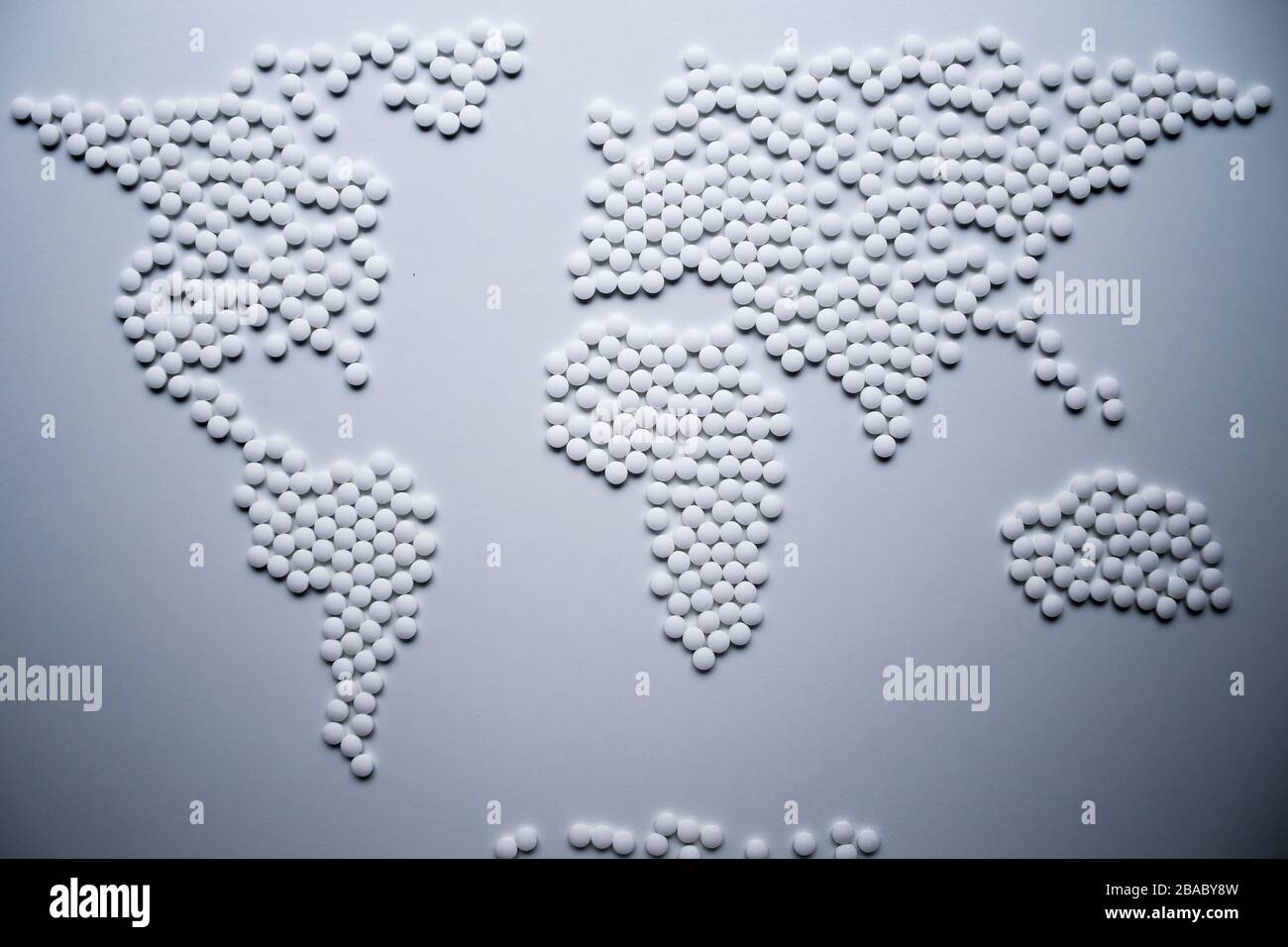 El concepto de mapa de salud mundial creado a partir de tabletas blancas necesita urgentemente para curar el mundo entero de virus e infecciones que amenazan a la población entera Foto de stock