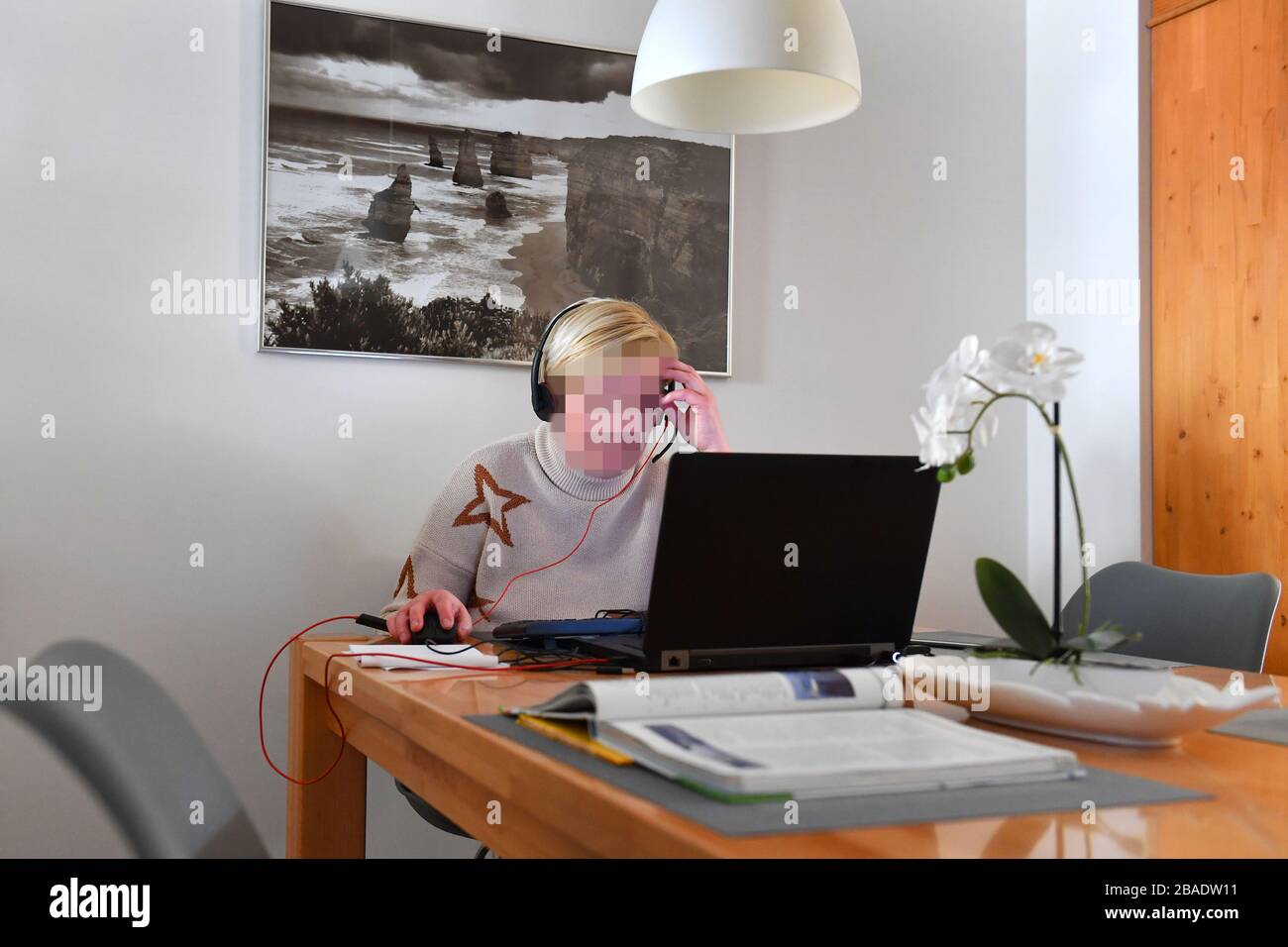 Munich, Alemania. 26 de marzo de 2020. Una mujer está sentada en su apartamento frente a un ordenador portátil con auriculares y está trabajando en la oficina debido a la corona, pandemia, propagación, crisis de corona, virus de corona, virus y patógeno. ? Sven Simon Fotoagentur GmbH & Co. Press Photo KG # Prinzess-Luise-Str. 41 # 45479 M uelheim/R uhr # Tel. 0208/9413250 # Fax. 0208/9413260 # GLS Bank # BLZ 430 609 67 # Kto. 4030 025 100 # IBAN DE75 4306 0967 4030 0251 00 # BIC GENODEM1GLS # WWW.SVENSIMON.NET. | uso en todo el mundo crédito: dpa/Alamy Live News Foto de stock