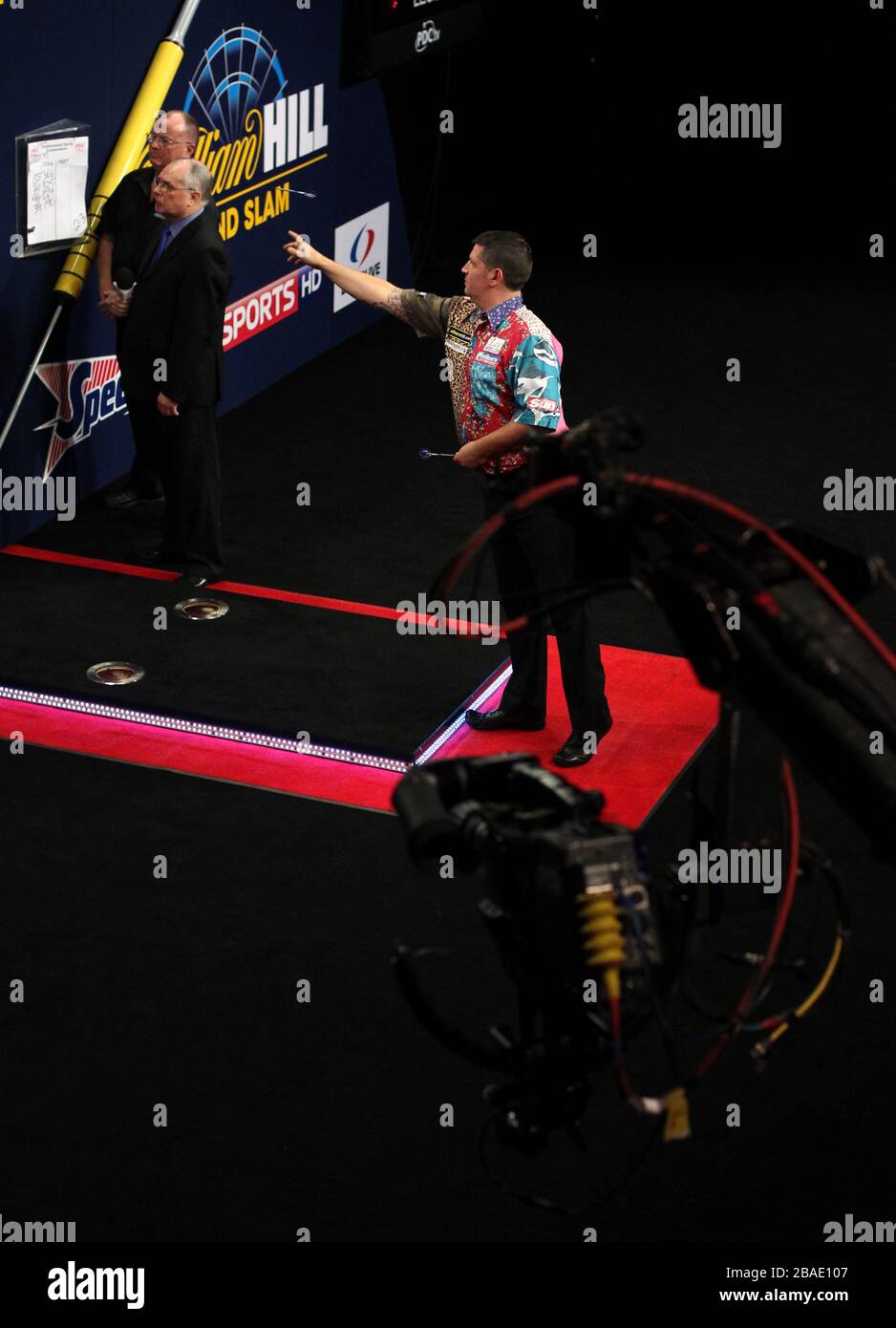 Gary Anderson es seguido por una cámara de TV mientras lleva una camisa multicolor Foto de stock