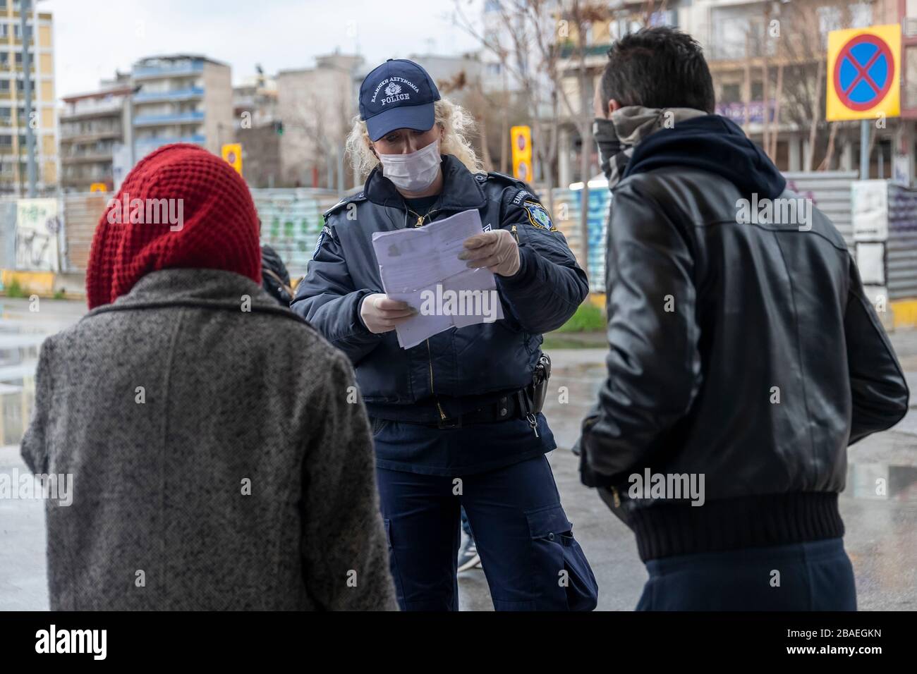 Tesalónica, Grecia - 23 de marzo de 2020: Un oficial de policía revisa los documentos de un ciudadano, mientras el país lucha por controlar la propagación del COVID Foto de stock