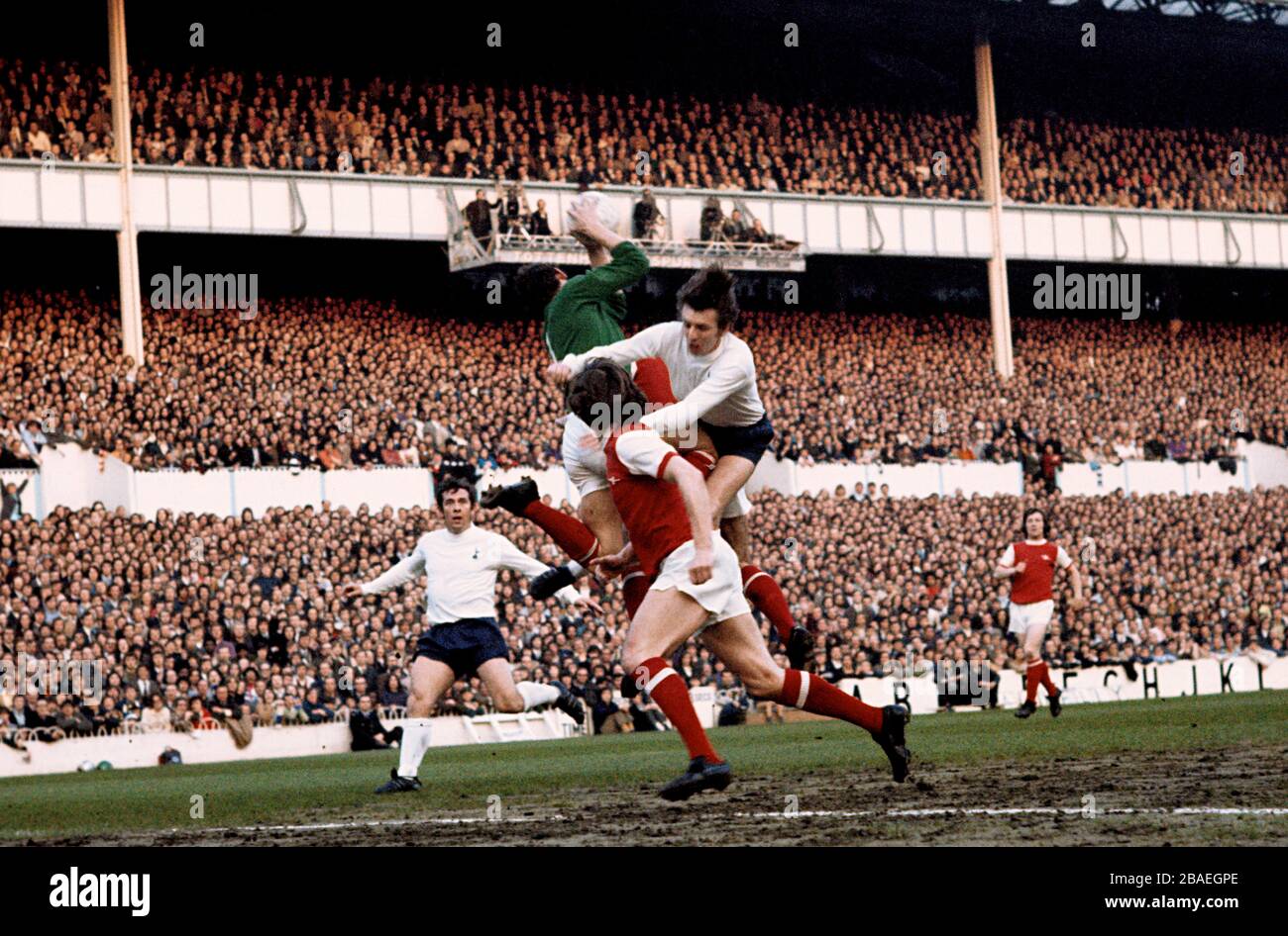 El portero del Arsenal, Bob Wilson (c), coge una cruz bajo presión del Tottenham Hotspur's Martin Peters (r), visto por el compañero de equipo Bob McNab (frente) y el Tottenham Hotspur's Alan Mulbertería (l) Foto de stock