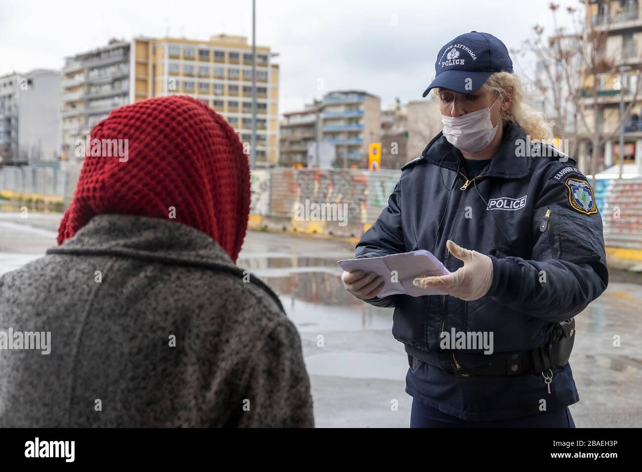 Tesalónica, Grecia - 23 de marzo de 2020: Un oficial de policía revisa los documentos de un ciudadano, mientras el país lucha por controlar la propagación del COVID Foto de stock