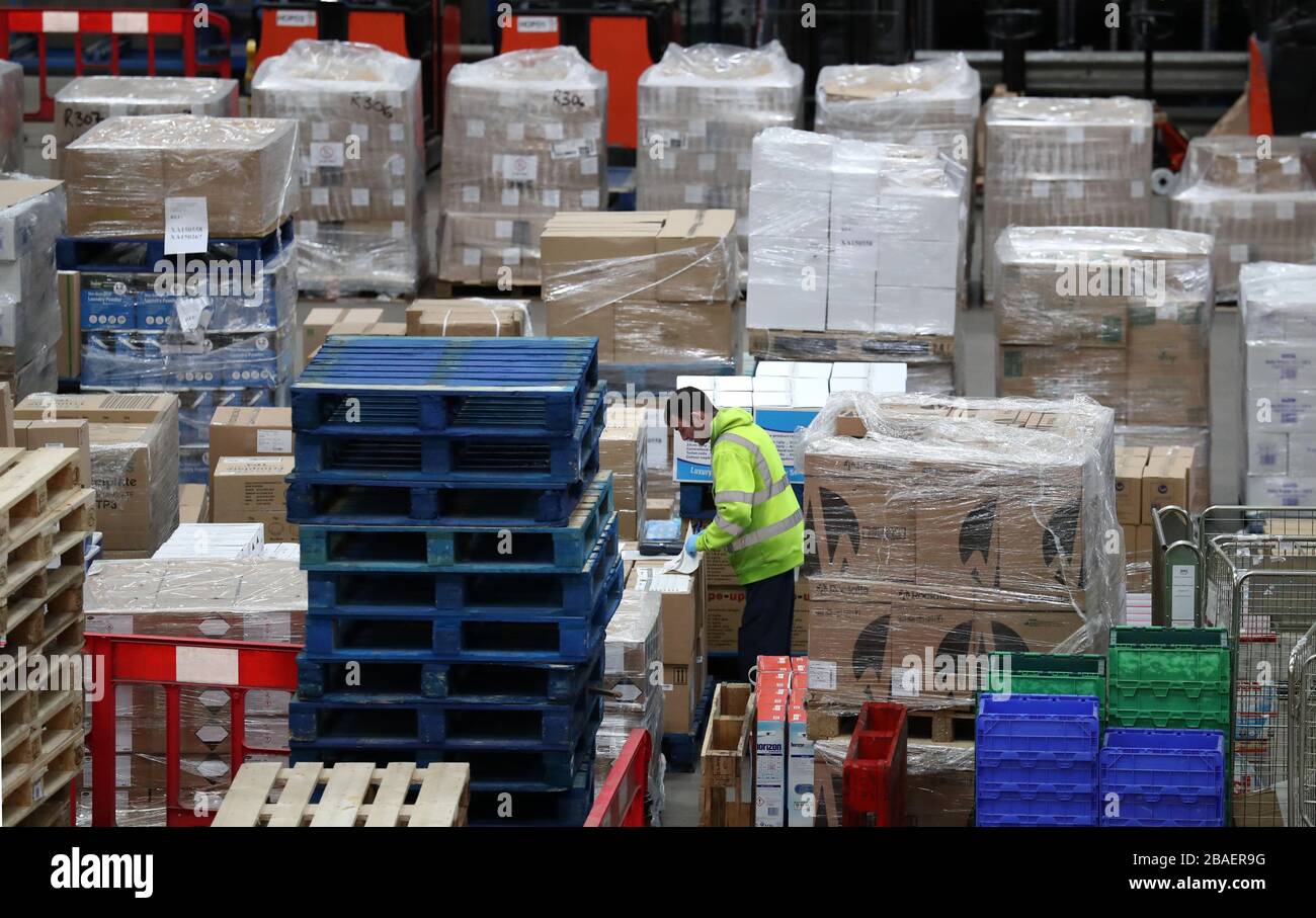 Un trabajador reúne suministros en el almacén Nacional de Compras del NHS en Canderside, Larkhall, ya que se están aumentando las entregas de equipo de protección personal (PPE), con millones de máscaras y guantes ya entregados al personal de primera línea. Foto de stock