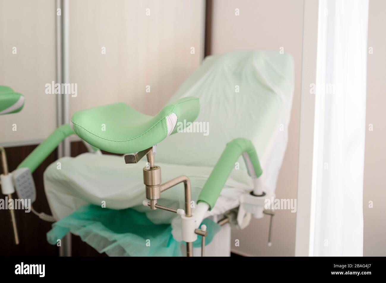 Silla ginecológica detrás de la pantalla. Consulta médica Fotografía de