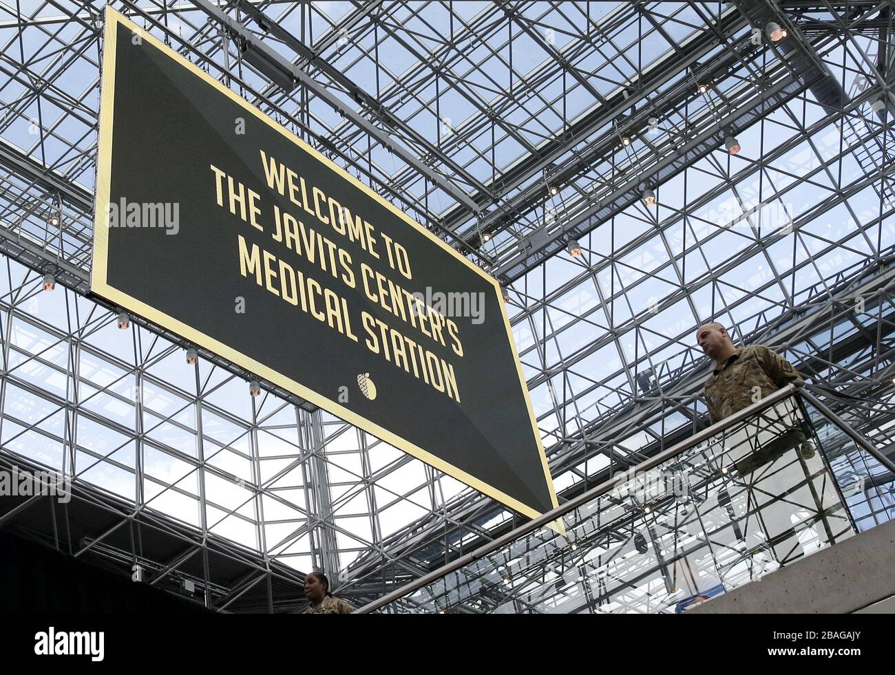 Una señal que dice Bienvenido a la estación médica Javits Center cuelga del techo de cristal mientras que Gov. Andrew Cuomo habla con la Guardia Nacional de Nueva York en el centro de convenciones Jacob K. Javits en la ciudad de Nueva York el viernes 27 de marzo de 2020. El Centro Javits se está estableciendo para ser convertido en hospitales de campo para probar y posiblemente tratar casos de infecciones COVID-19. Casi la mitad de los Estados Unidos están bajo órdenes de permanecer en el hogar y los Estados Unidos se han convertido en el país con los casos de coronavirus más confirmados en más de 94,000. Foto de John Angelillo/UPI Foto de stock