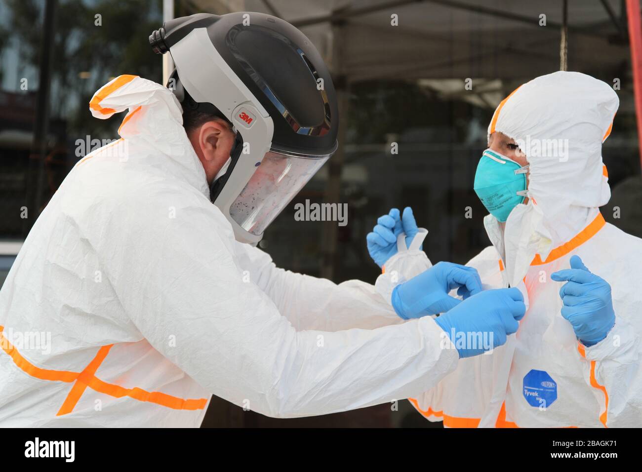 San Mateo, Estados Unidos. 27 de Mar de 2020. Un miembro de la Guardia Estatal de California y un miembro del personal de la Autoridad de Servicios médicos de emergencia de California se suplan con equipo de protección personal antes de ayudar a tratar a pacientes con COVID-19 Marzo 27, 2020 en el Condado de San Mateo, California. Crédito: Eddie Siguenza/US Army/Alamy Live News Foto de stock