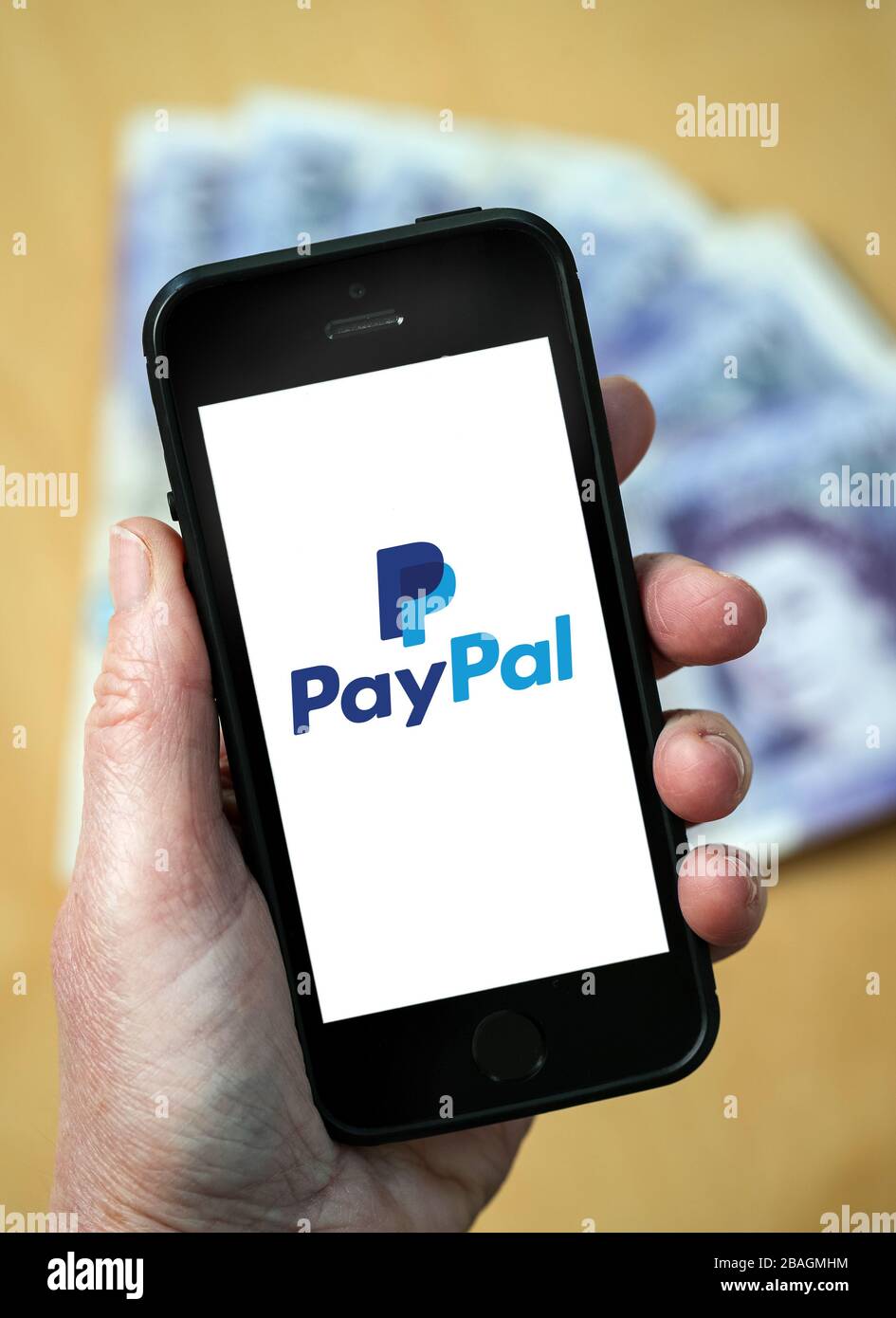 Una mujer mirando el logotipo de PayPal en un teléfono móvil. (Sólo para  uso editorial Fotografía de stock - Alamy