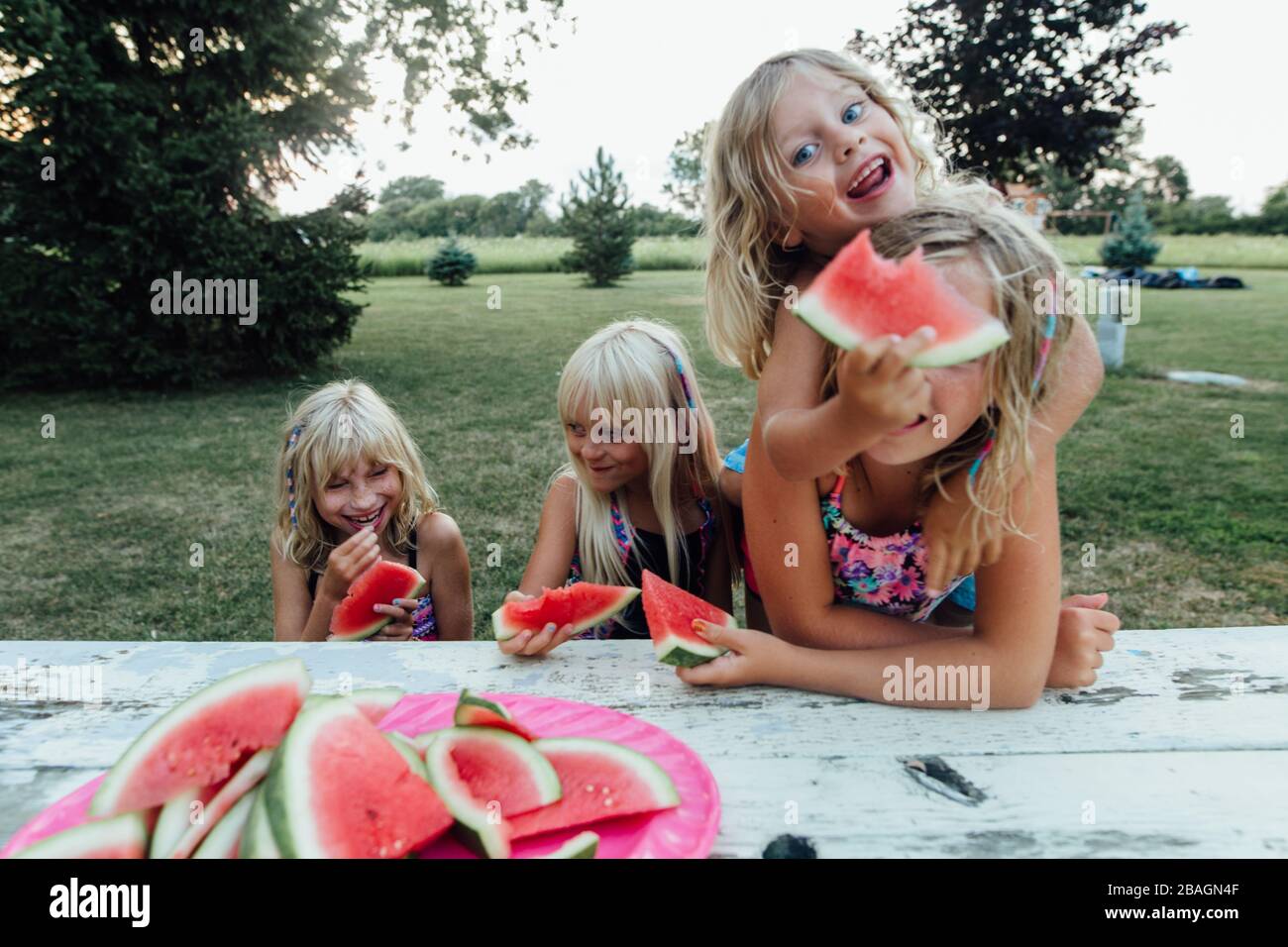 los niños que comen tontos sandía afuera en el verano Foto de stock