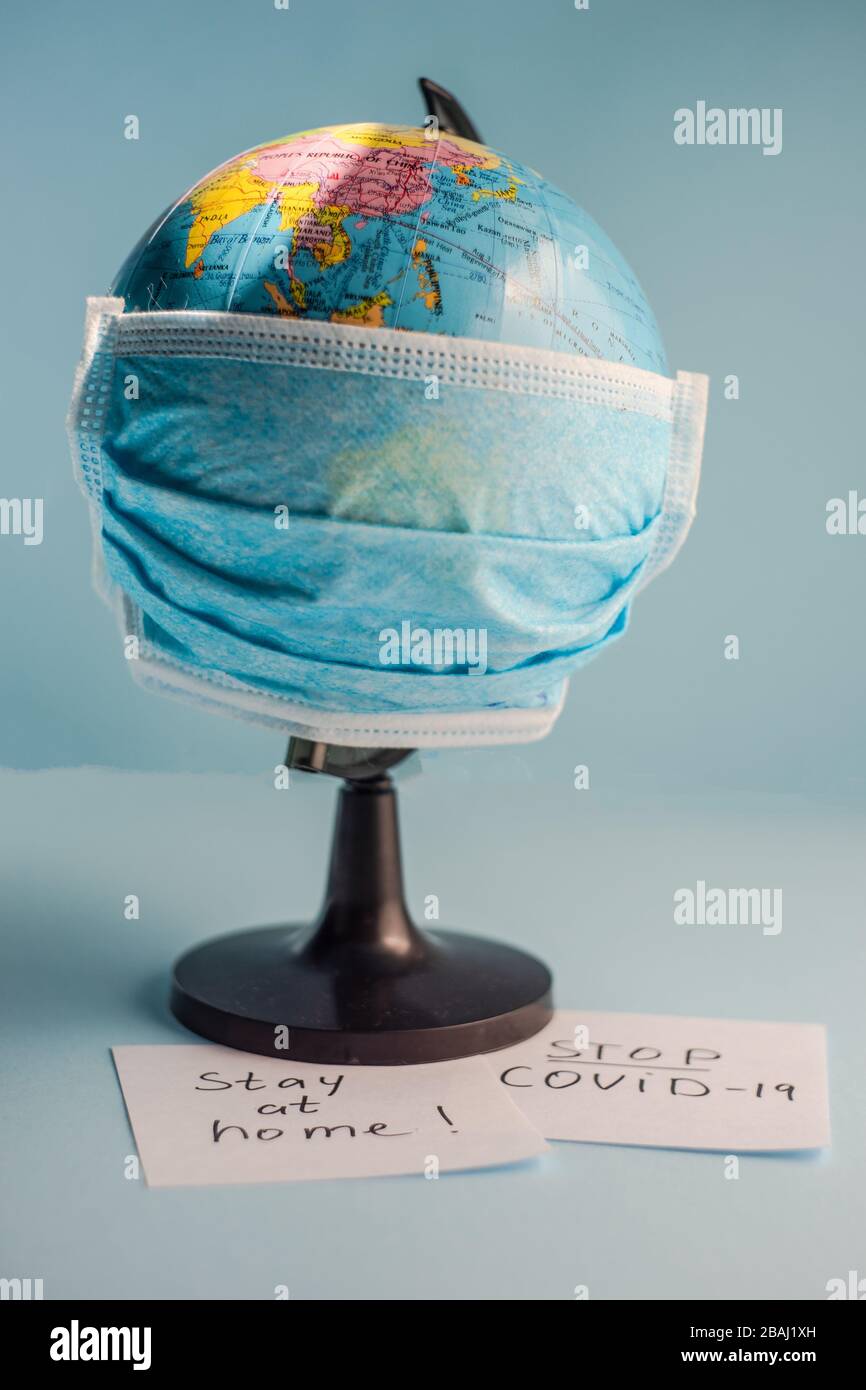 Concepto de virus COVID-19 con globo terráqueo en máscara de cara sobre  fondo pastel con espacio de notas y copias Fotografía de stock - Alamy