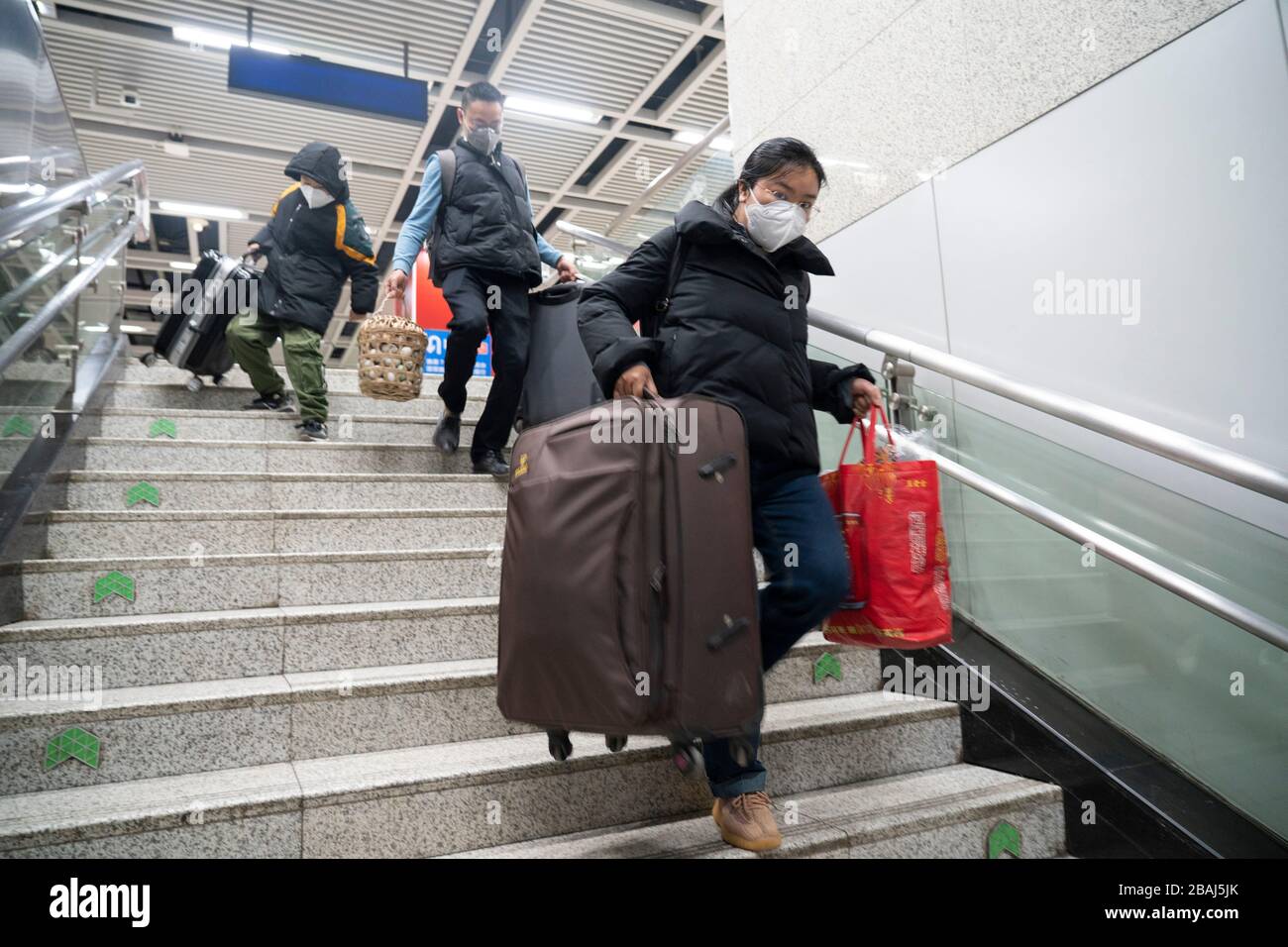 Wuhan, provincia China de Hubei. 28 de marzo de 2020. Los pasajeros van abajo en la estación de metro de la estación de tren de Wuchang, en Wuhan, provincia de Hubei, en el centro de China, el 28 de marzo de 2020. Seis líneas de metro en Wuhan reanudaron sus operaciones a partir del sábado, una nueva señal de que la vida está volviendo gradualmente a la normalidad en la ciudad más afectada. Los pasajeros deben escanear el código QR para registrar nombres reales y realizar comprobaciones de temperatura antes de tomar el metro. Cada tren está equipado con un miembro de la tripulación de seguridad para ayudar a guiar y servir a los pasajeros. Crédito: Cai Yang/Xinhua/Alamy Noticias en vivo Foto de stock