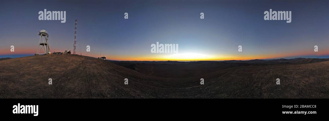 'Inglés: El sol se ha puesto sobre el desierto de Atacama y el horizonte se convierte en diferentes tonos de naranja y rojo. Venus es visible a la derecha como un punto brillante en el cielo azul claro. Esta impresionante vista panorámica fue tomada desde Cerro Armarzones, una montaña de 3060 metros de altura en la II Región de Chile y a unos 20 km de Cerro Paranal, hogar del Telescopio muy Grande eso (VLT). Cerro Armazones es el sitio seleccionado para el Telescopio Europeo extremadamente Grande (E-ELT), que, con su espejo de 40 metros de diámetro, será el ojo más grande del mundo en el cielo.; 26 de febrero de 2011; http://www.eso.or Foto de stock