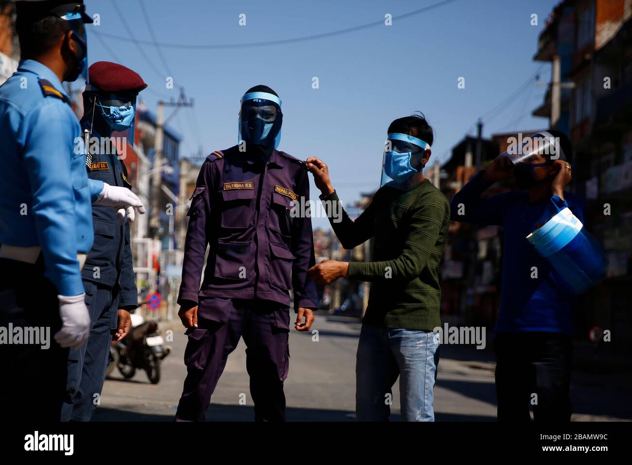 Katmandú, Nepal. 28 de marzo de 2020. El personal de la policía trata de escudos de cara sin cargos por parte de la población local de Gillibazar el quinto día de gobierno impuso un bloqueo en medio de preocupaciones sobre la pandemia de coronavirus en Katmandú, Nepal, el sábado 28 de marzo de 2020. Crédito: Skanda Gautam/ZUMA Wire/Alamy Live News Foto de stock