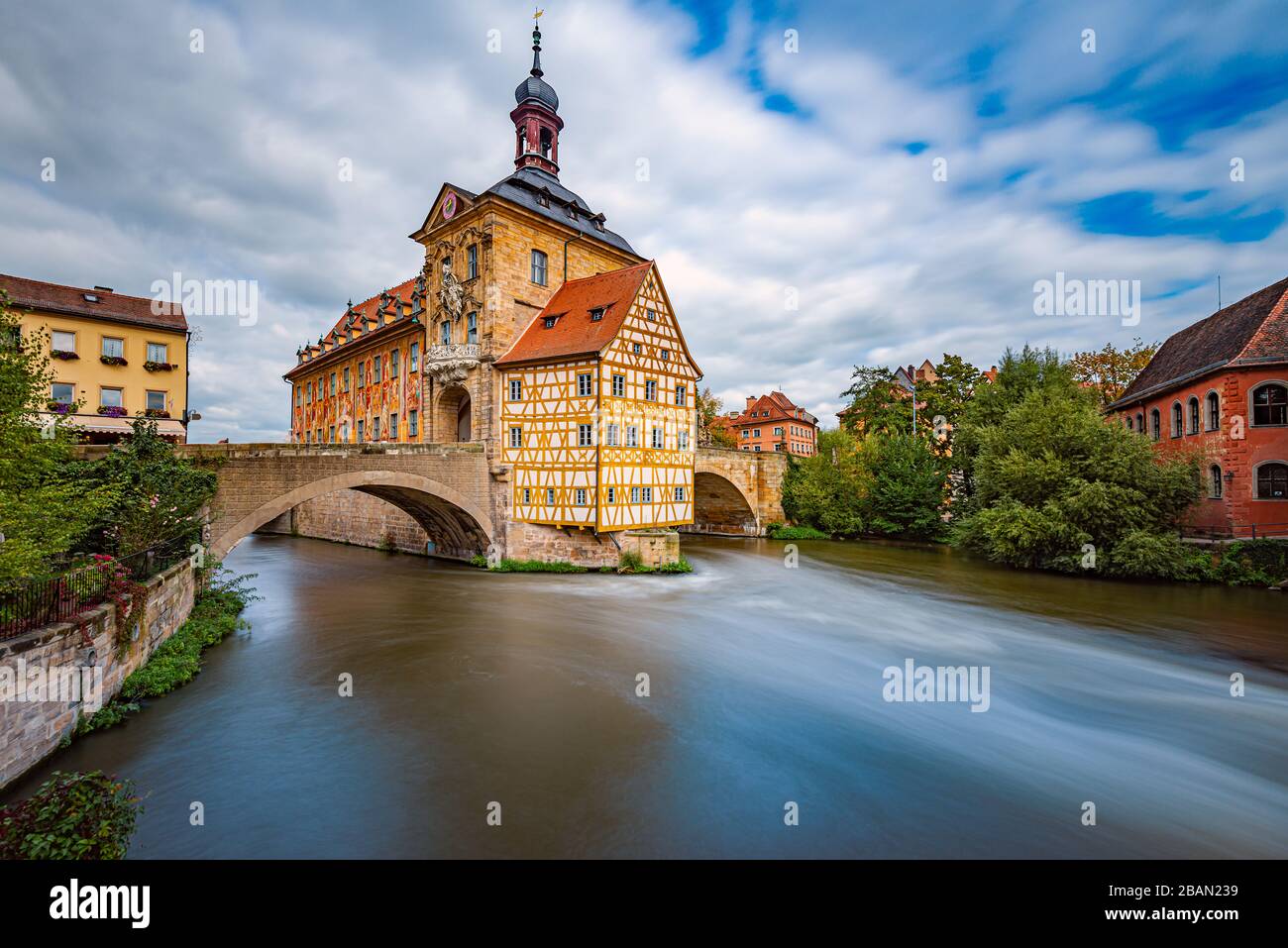 Bamberg ciudad en Alemania. Edificio del ayuntamiento en el fondo con cielo azul nublado. Arquitectura y viajes en Europa. Río que fluye en primer plano. Foto de stock