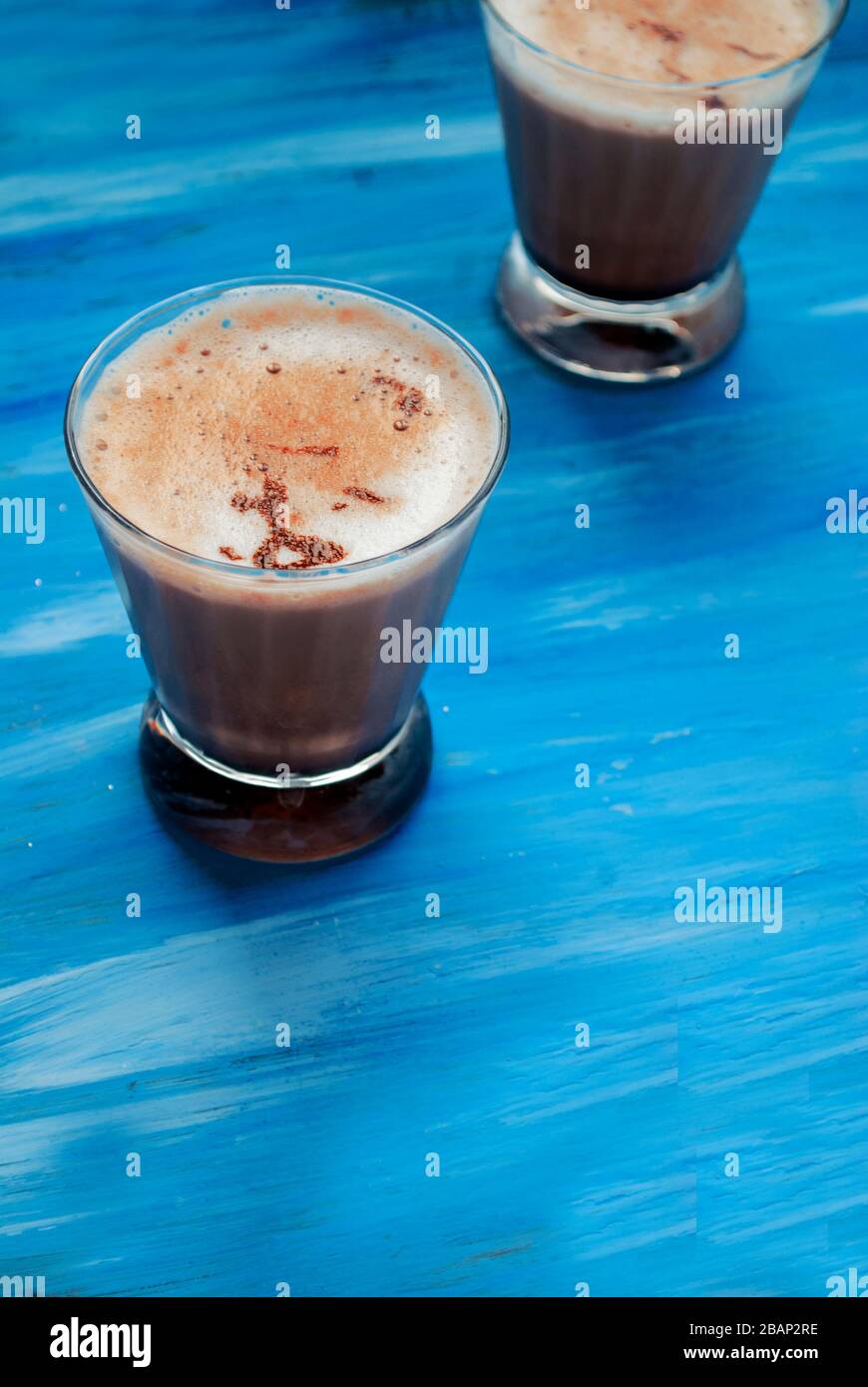 https://c8.alamy.com/compes/2bap2re/dos-vasos-de-latte-sobre-un-fondo-azul-colocar-para-texto-2bap2re.jpg