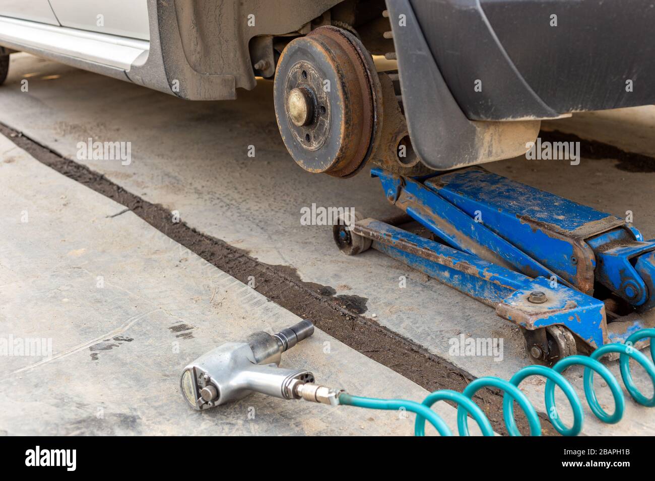 Coche levantado por un gato neumático Fotografía de stock - Alamy