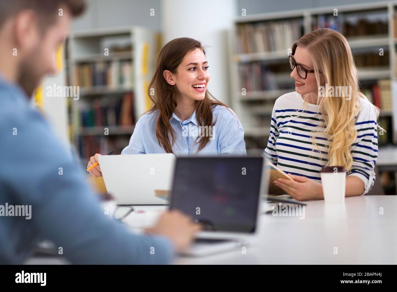 Estudiantes universitarios que trabajan en la biblioteca en el campus Foto de stock