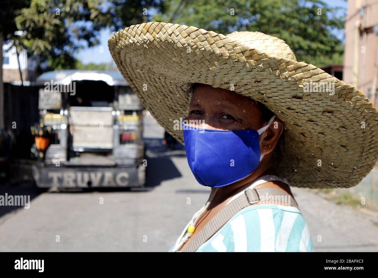 va a decidir Comiendo Arne Antipolo City, Filipinas - 28 de marzo de 2020: La mujer filipina adulta  usa máscara facial como protección contra el brote del virus Covid 19 y un sombrero  ancho contra el calor