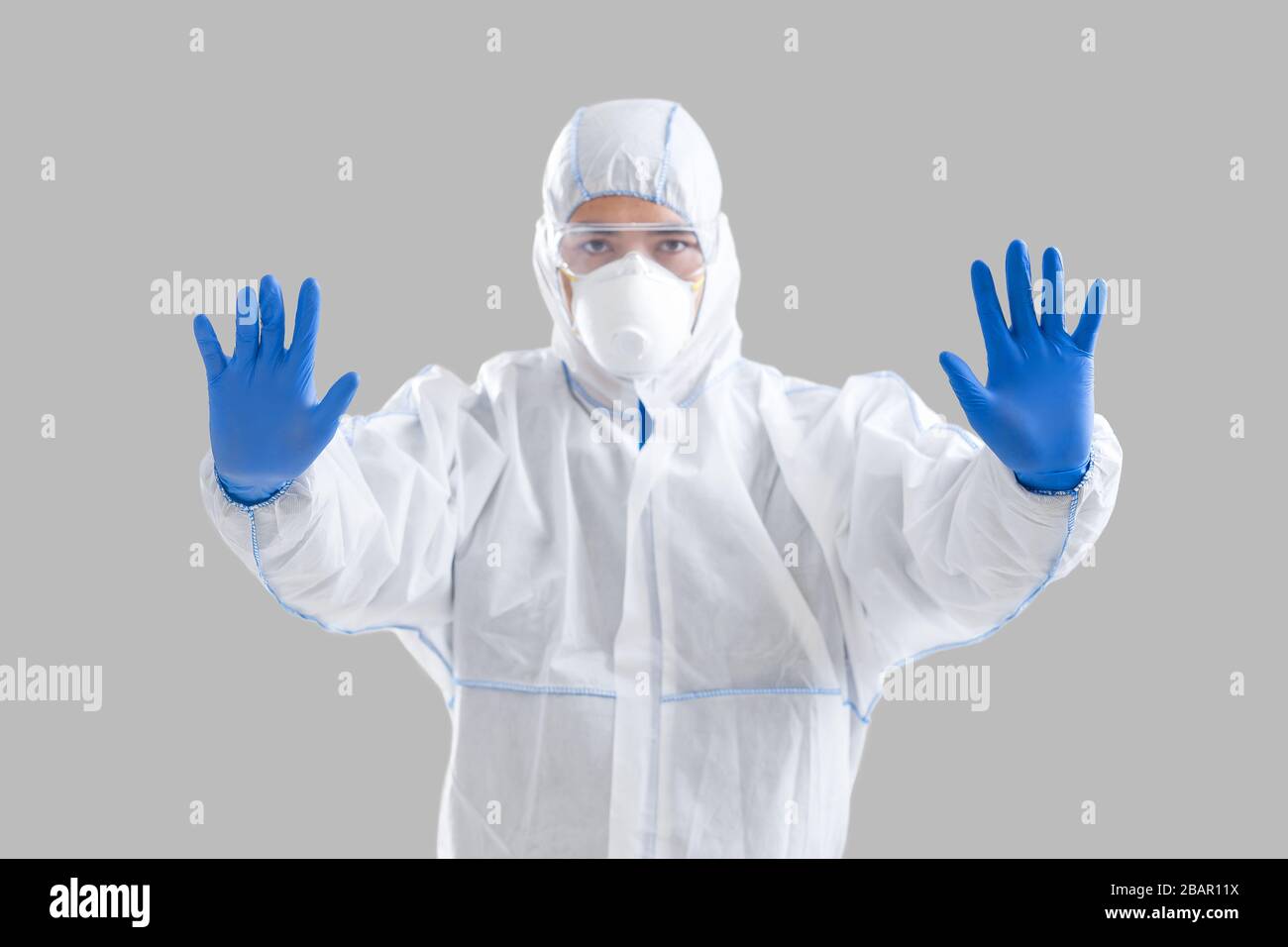Virólogo en máscara y traje protector, detener la epidemia de coronavirus Foto de stock