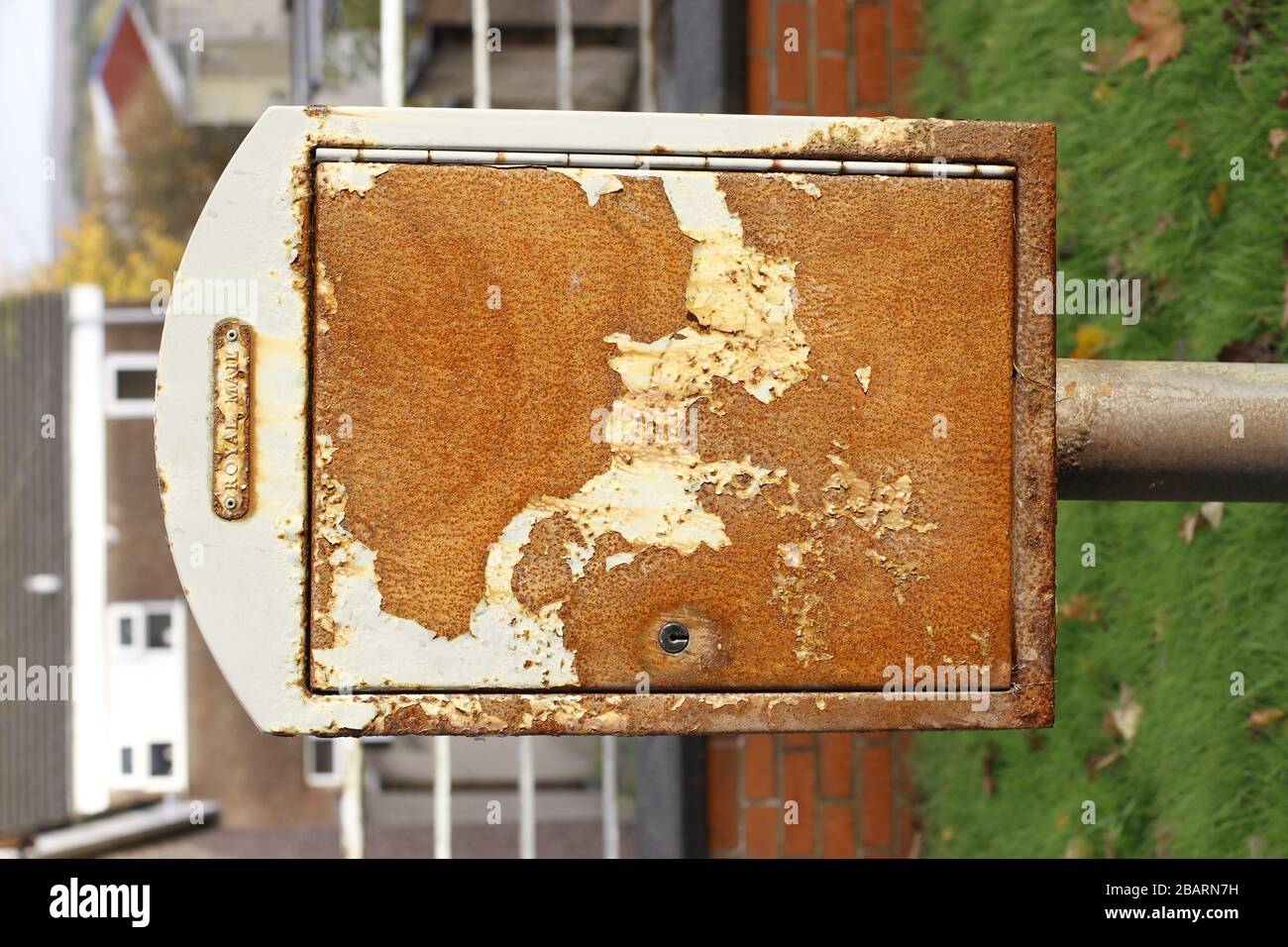 Una caja de correo Royal Mail de estilo antiguo ahora oxidada y desgastada al lado de una carretera en el Reino Unido Foto de stock
