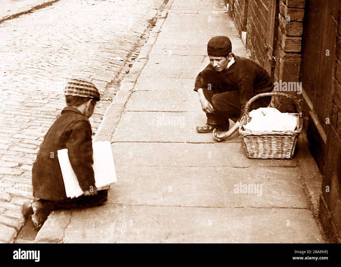 Entrega chicos jugando mármoles, época victoriana Foto de stock