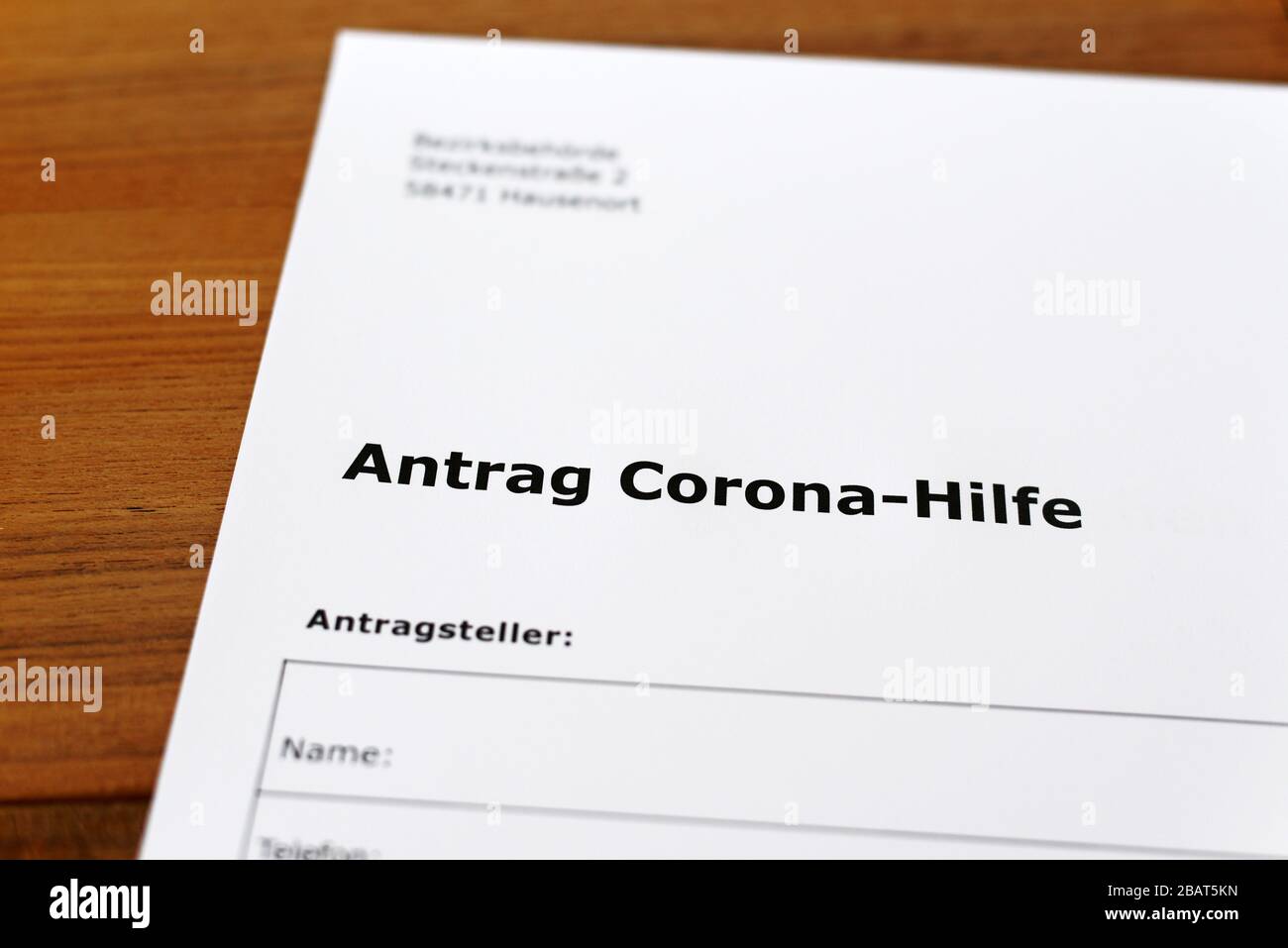 Una hoja de papel con las palabras alemanas 'Antrag Corona-Hilfe' - Traducción en englisch: Solicitud de ayuda Corona. Foto de stock