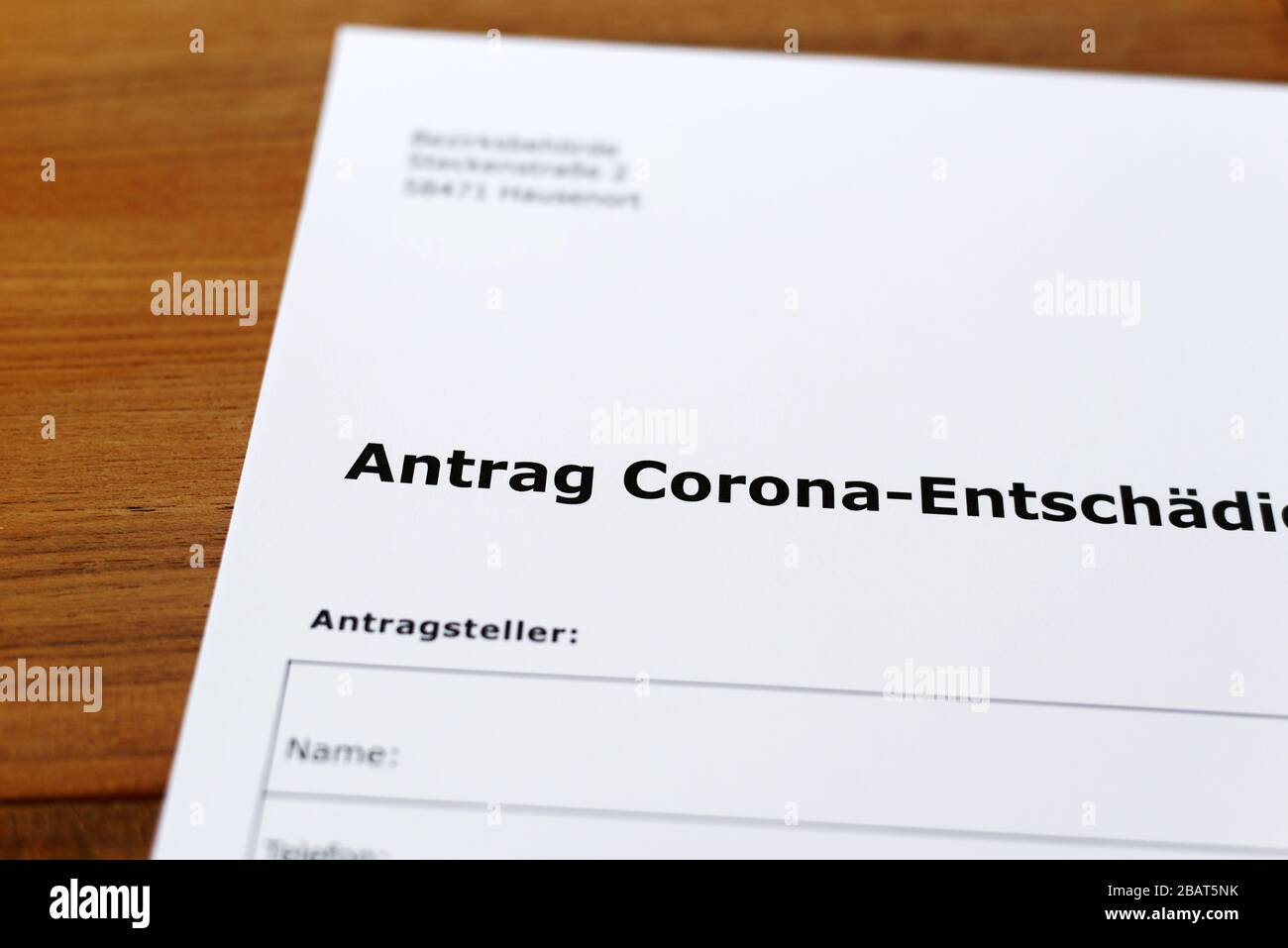 Una hoja de papel con las palabras alemanas 'Antrag Corona Entschädigung' - Traducción en englisch: Solicitud de indemnización Corona. Foto de stock