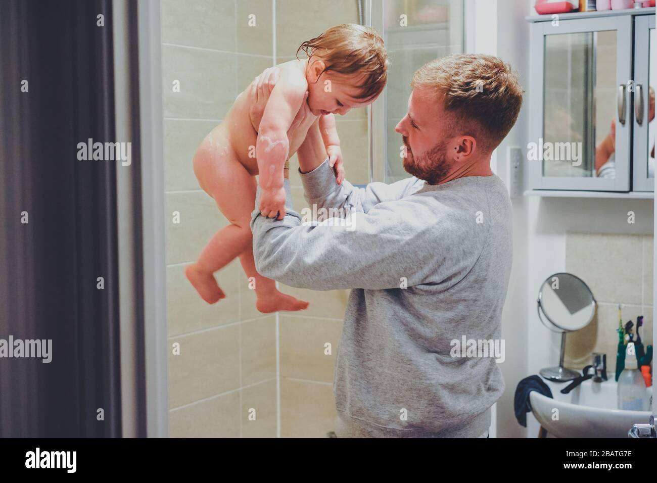 Papá sacando a un niño de la bañera Foto de stock