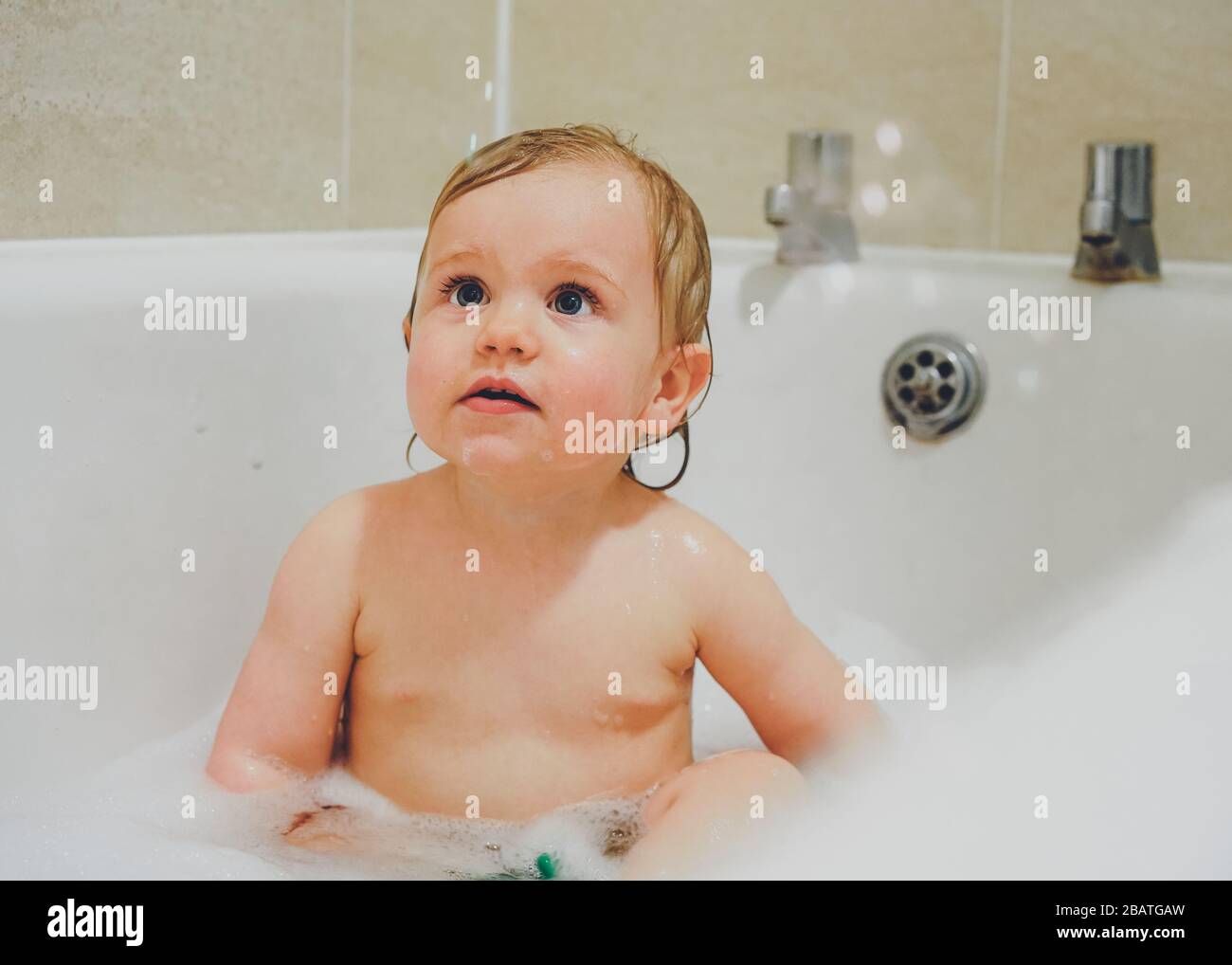Niño jugando en el baño con burbujas Foto de stock