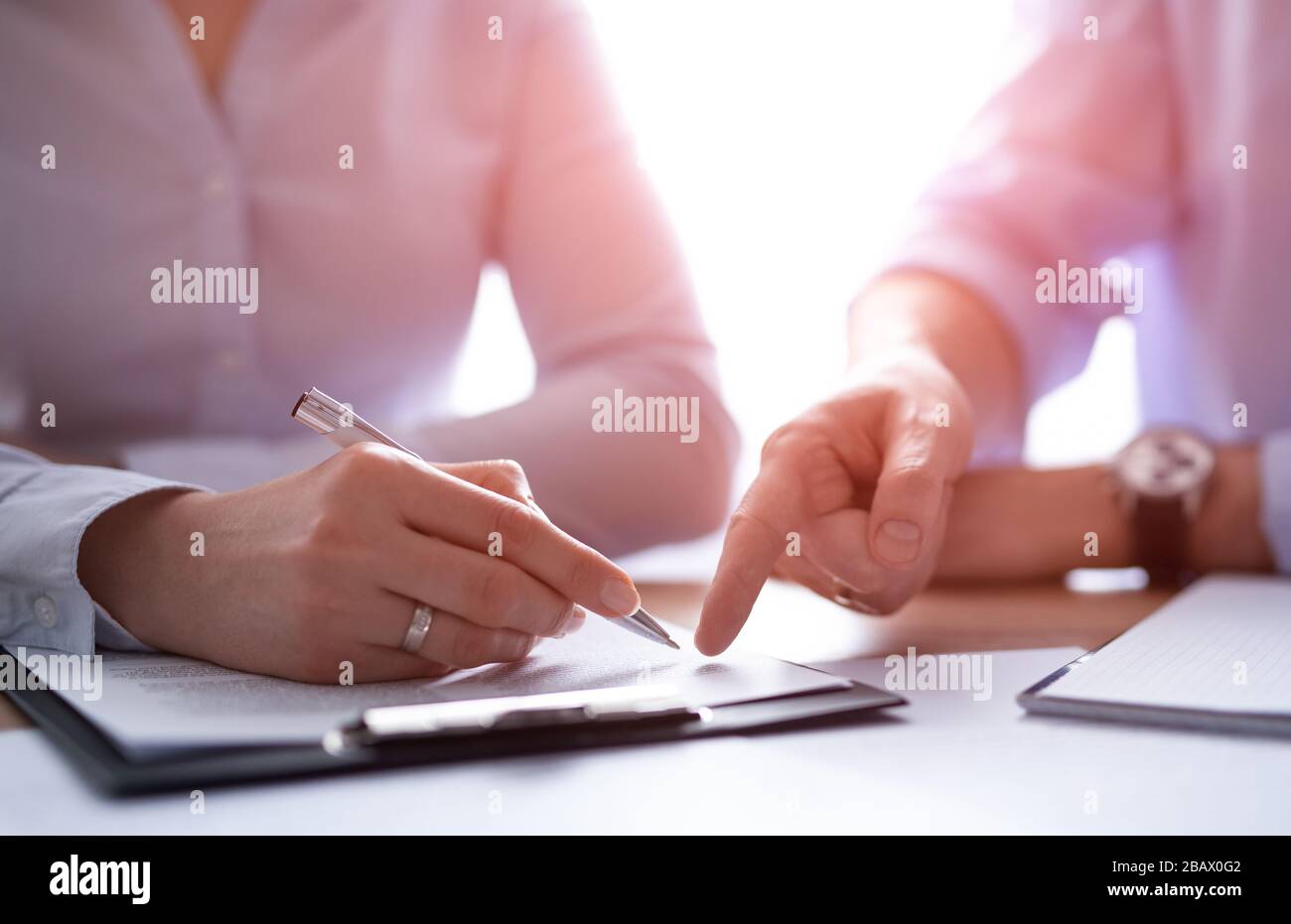 Empresarios que negocian un contrato. Manos humanas trabajando con documentos en el escritorio y firmando el contrato. Foto de stock