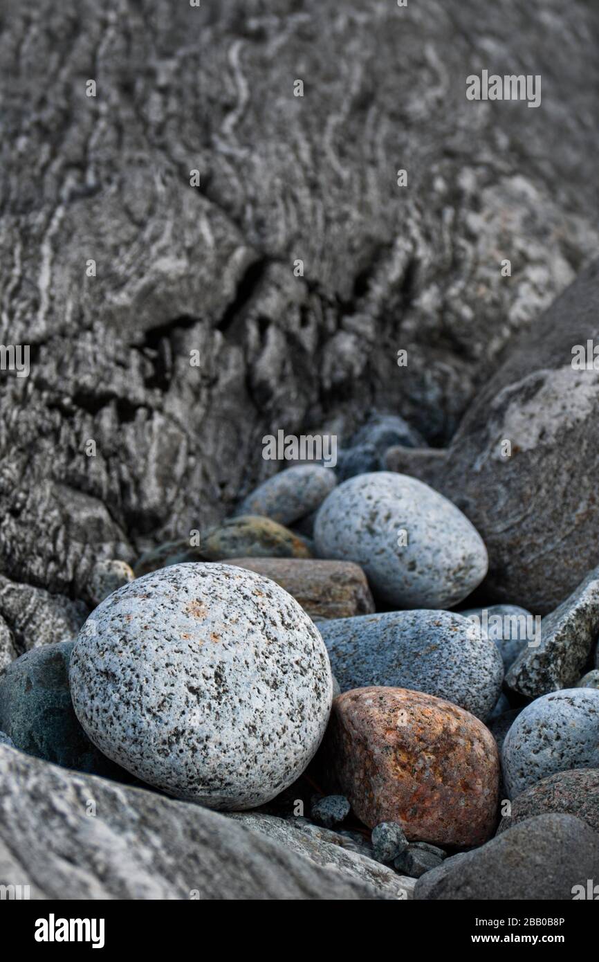 Piedras redondas de granito se encuentran frente a una roca en una playa rocosa. Mar Báltico, Västernorrland, Suecia, Europa Foto de stock