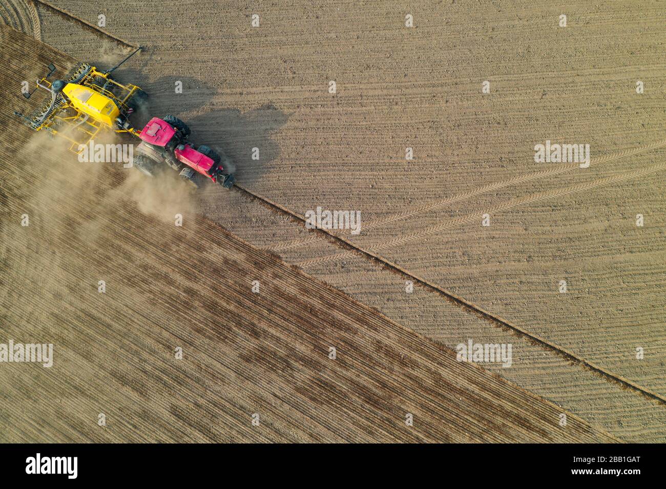 Drone pov del tractor sembrando maíz en campo, vista aérea de la actividad agrícola Foto de stock